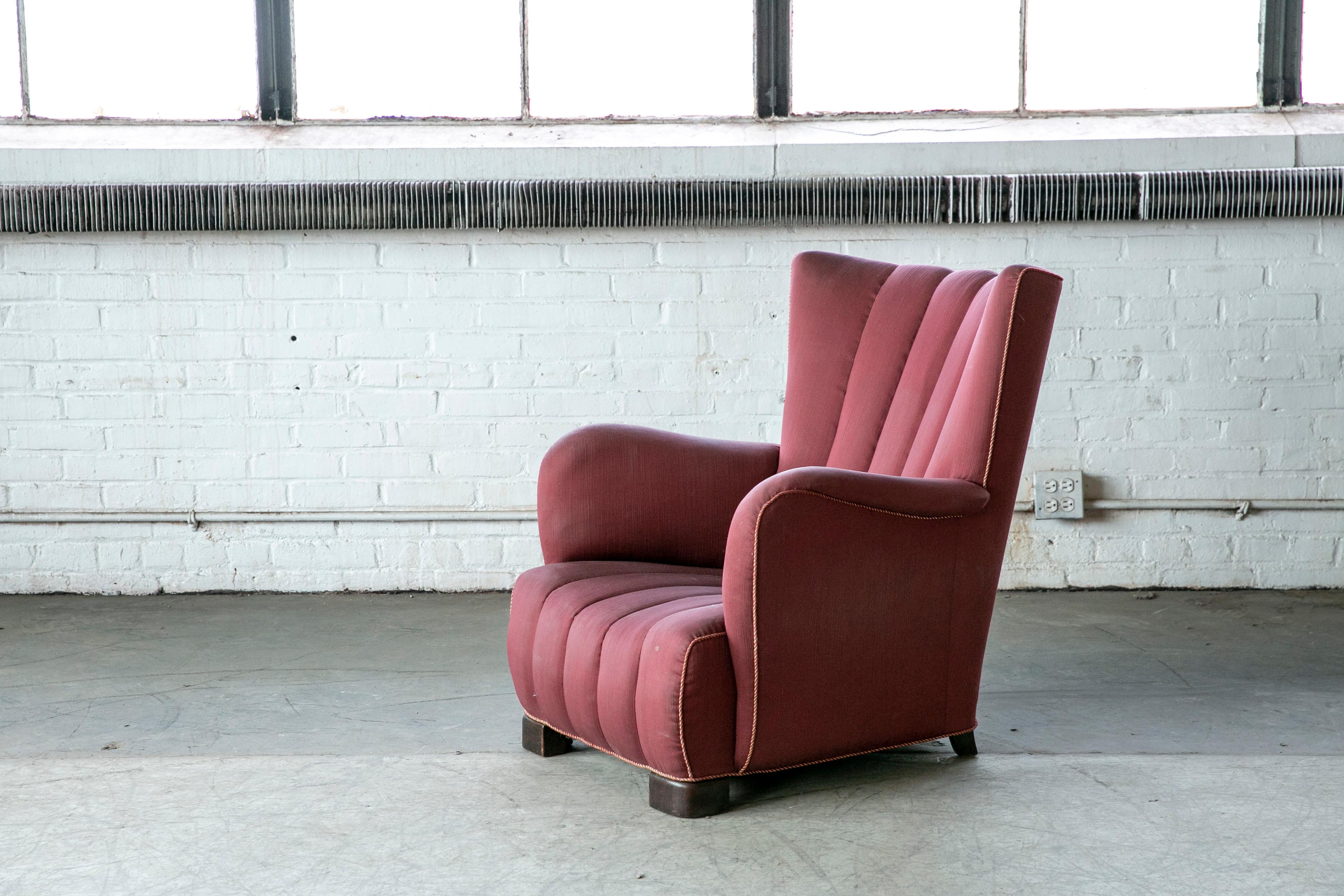 Unique highback lounge chair with channeled back and seat made in Denmark in the late 1930s or early 1940s. Unual to see channels both in the back and the seat. Very much in the style of Fritz Hansen and his model 1672. Solid and sturdy with coil