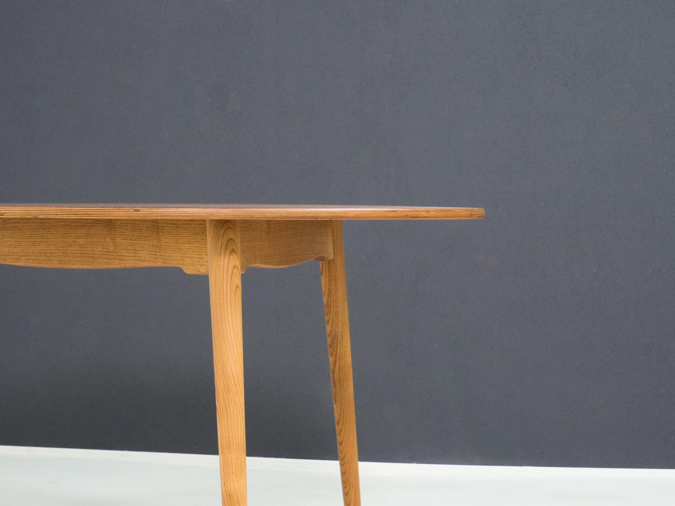 Dining table design by Hans J. Wegner for Fritz Hansen of Denmark in the 1950s.

This table has a plywood top that is veneered in teak, the frame and legs are made of solid ash wood which makes for a classic two tone look.

The table is in good