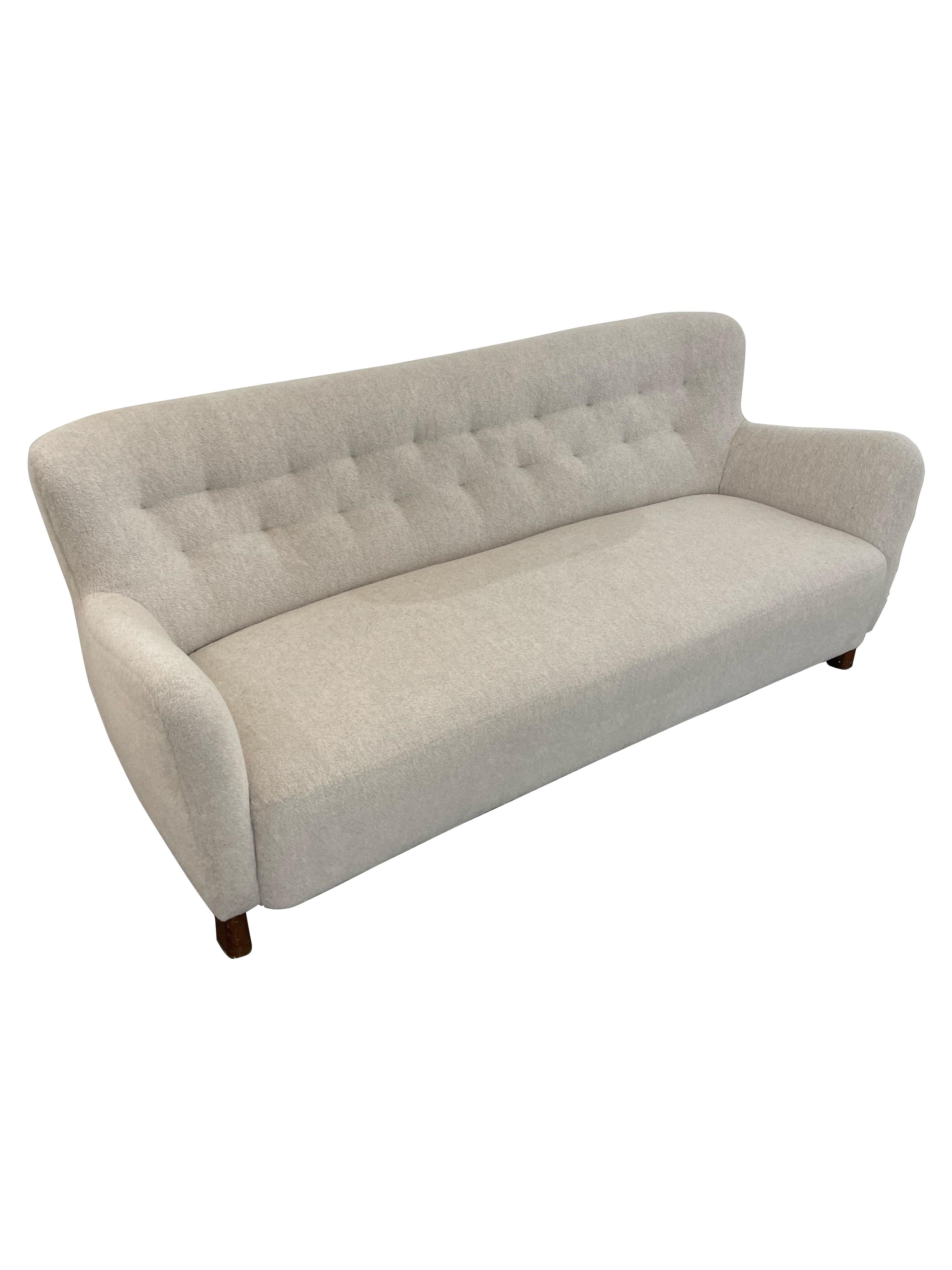 An iconic Fritz Hansen 3-Seat Sofa, a true masterpiece of Danish design. Crafted in Denmark in 1940, this sofa showcases the impeccable craftsmanship and attention to detail that Hansen is renowned for. The sofa is upholstered in sumptuous brushed
