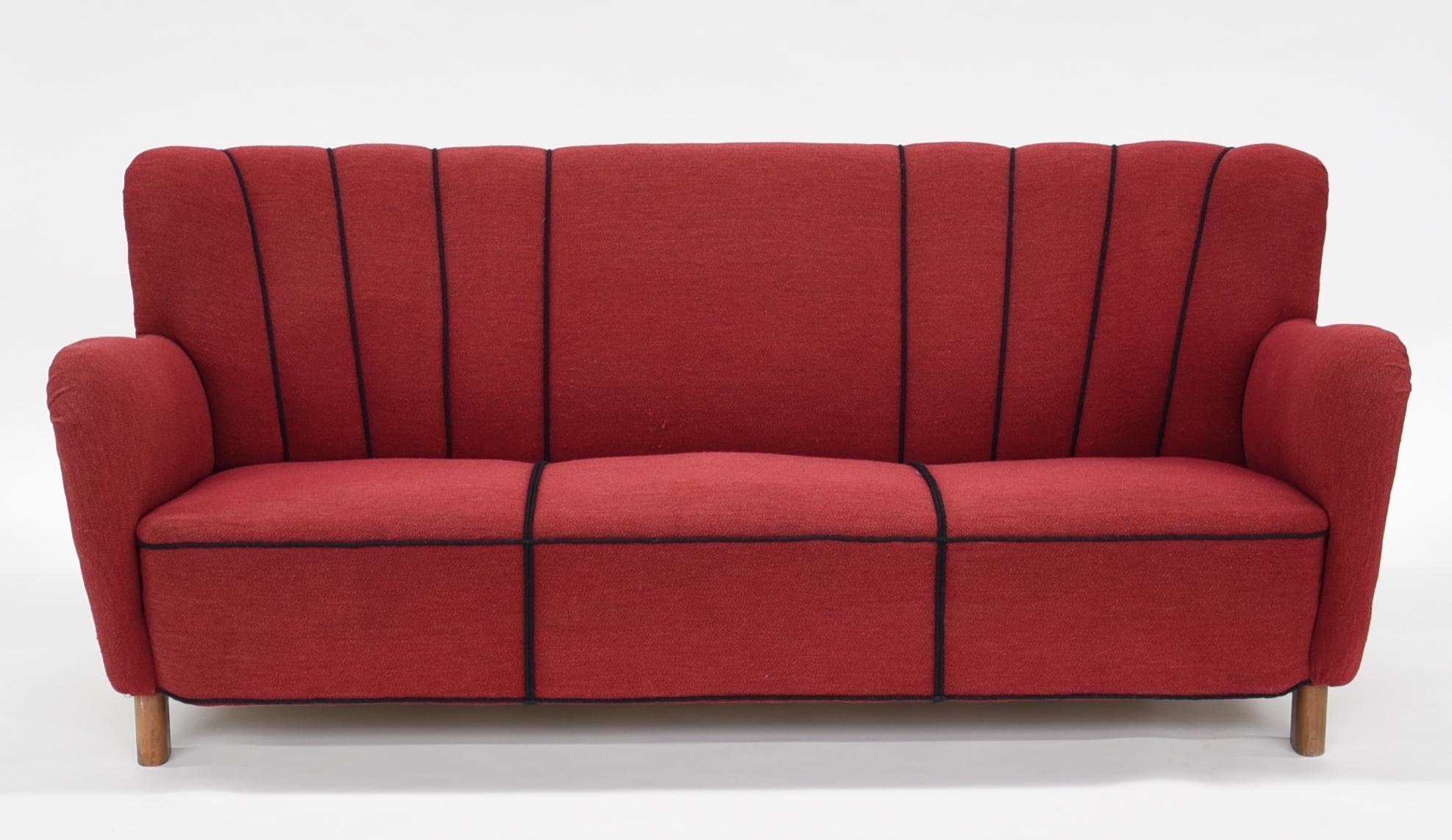 Fritz Hansen three-seat sofa, model 1669A, with oval beech legs, later reupholstered in wool.
Designed and produced by Fritz Hansen. 
Measures: H. 75 cm., L. 185 cm., D. 84 cm. 
Label underneath. 
Literature: Catalogue from Fritz Hansen, 1942,