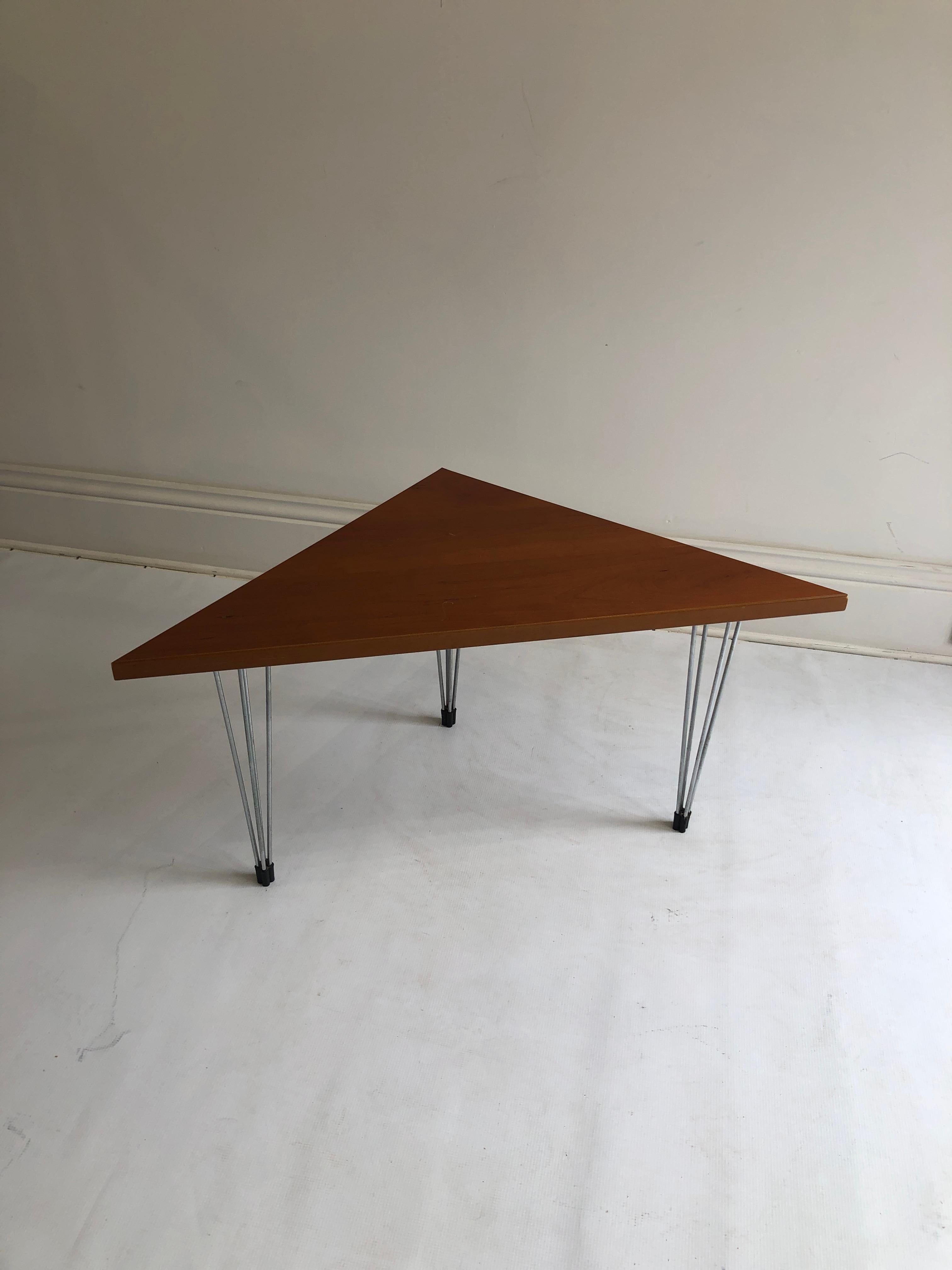 A postmodern by Fritz Hansen in triangular birch top in dark orange/teak colour. The tabletop is supported by three metal chromed hairpin-like legs, with their plastic feet. The side table has been manufactured in 1980s and is great example of