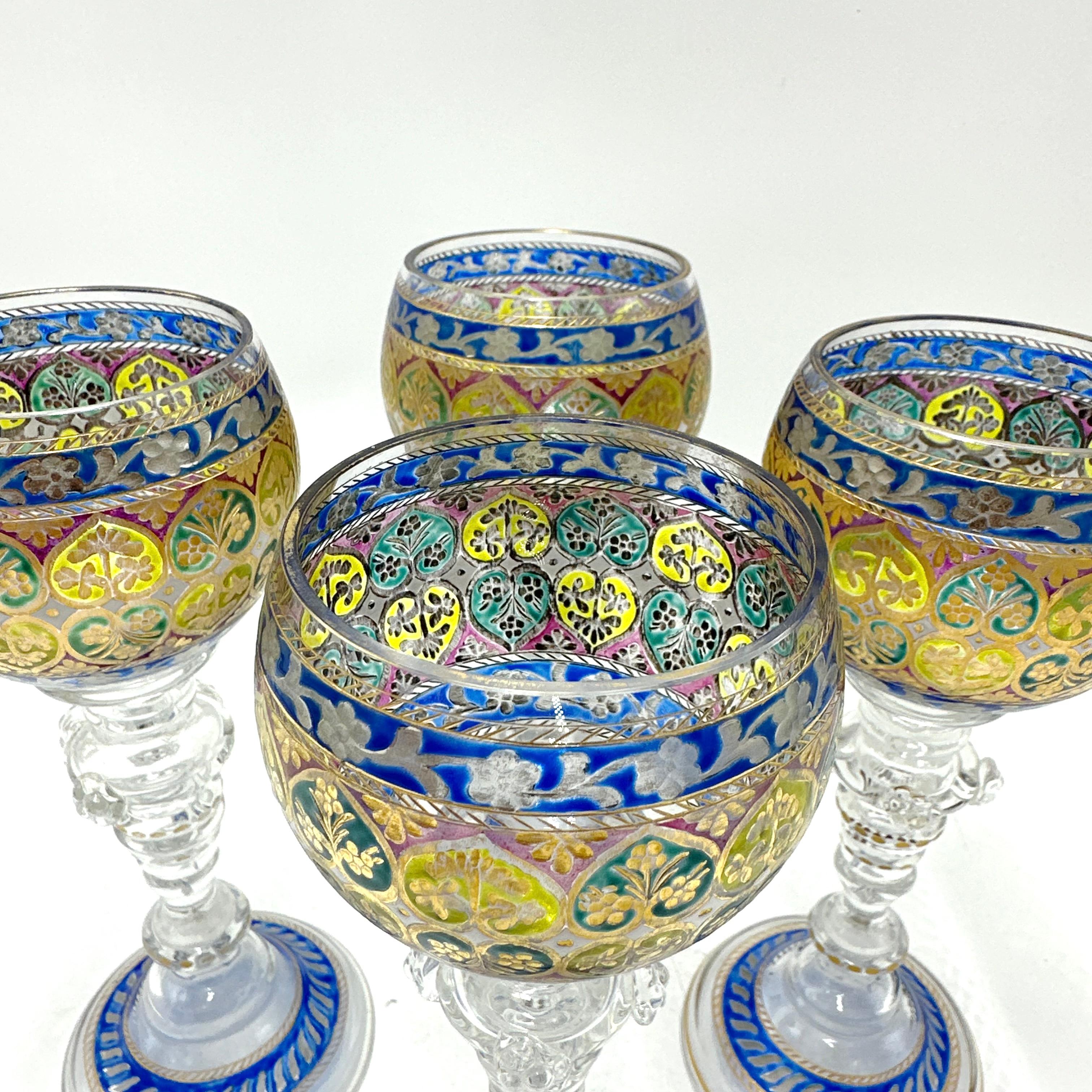 This exquisite set of 4 x enameled Bohemian goblets is attributed to Fritz Heckert, a master glassmaker renowned for his detailed hand-painted designs. Each goblet is a striking example of 19th-century luxury glassware, featuring intricate gilded
