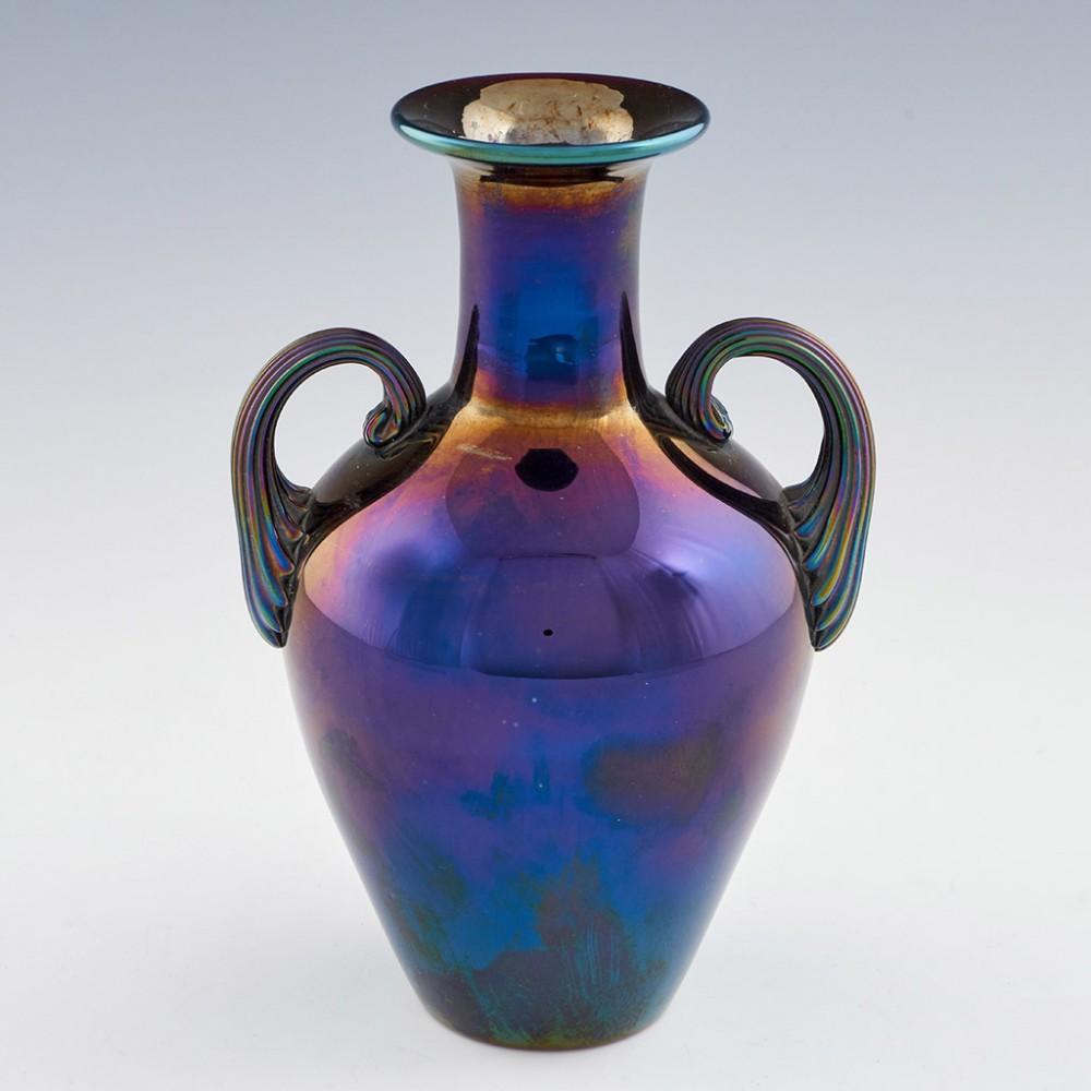 Fritz Heckert - Max Rade Iridised Glass Amphora made 1881-1910 in Petersdorf, Austria. Purple, iridised amphora shaped with two handles

Condition : Excellent; no chips, cracks or flakes; a very few tiny air bubbles at the surface and a single 6mm