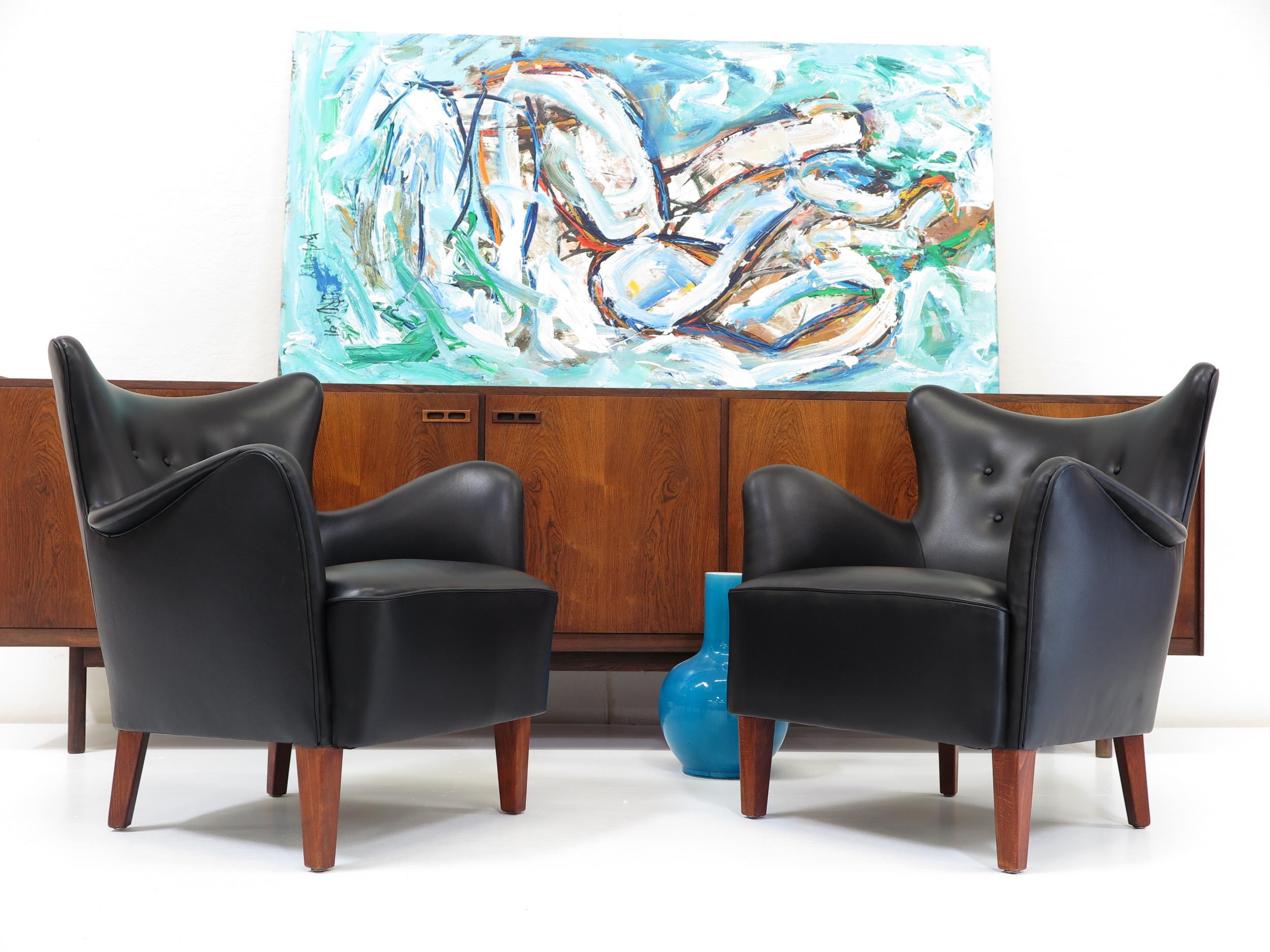 Early Scandinavian lounge chairs designed by master cabinetmaker Frits Henningsen, Denmark. Hand-crafted hardwood frames with superior joinery, newly upholstered in a fine black leather over eight-way hand tied spring seats and horsehair and cotton