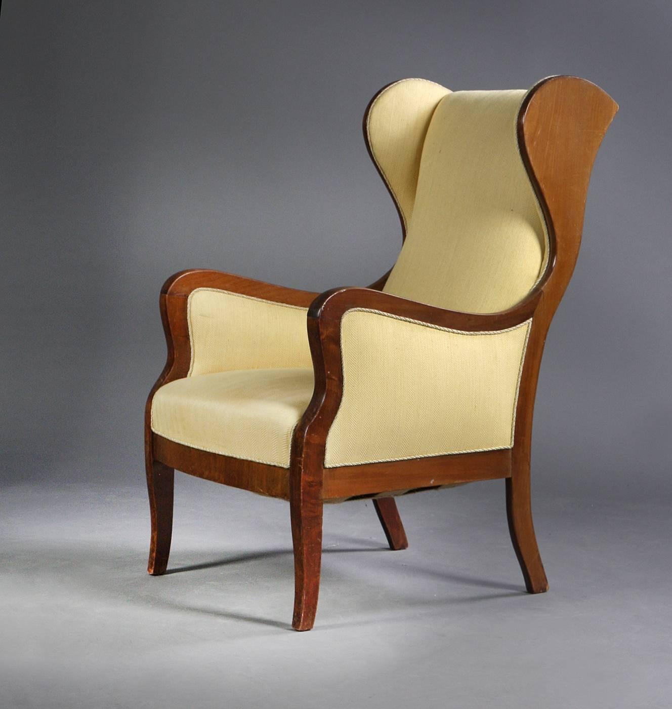 Beautiful classic 1930s-1940s solid mahogany wingback chair produced by Master Cabinetmaker Frits Henningsen, Denmark. Very elegant design that fits superbly into any modern design making a strong yet refined statement. Some wear to the varnish and