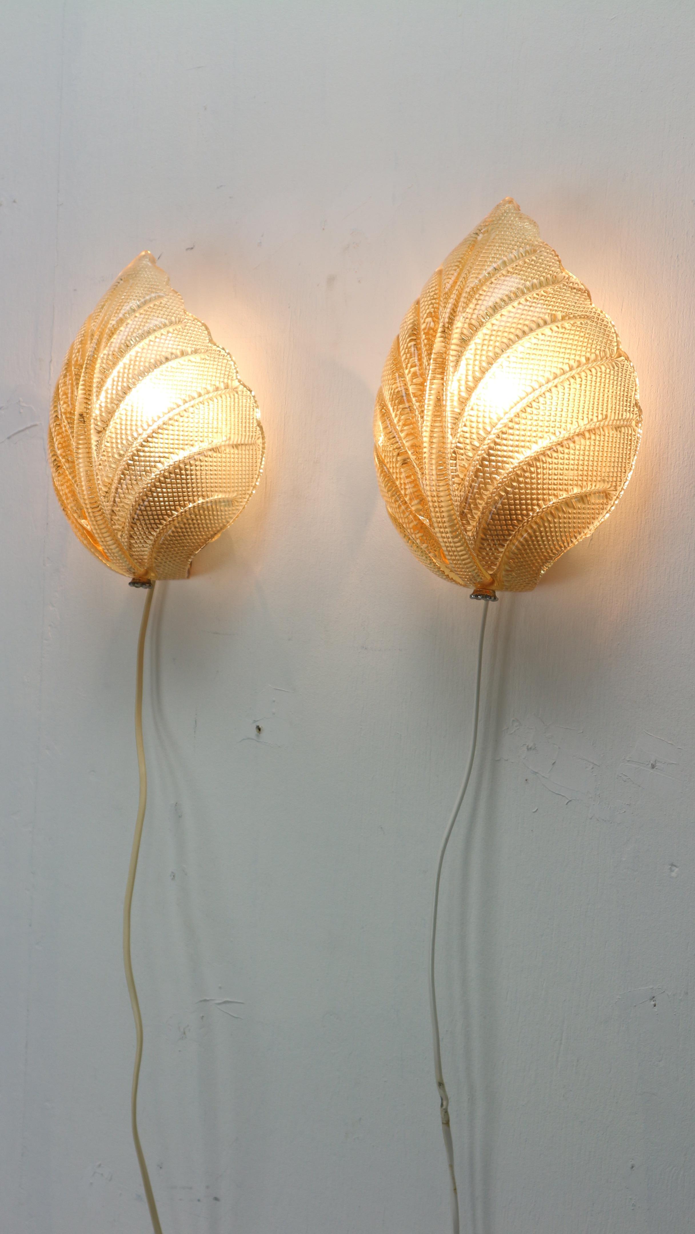 Scandinavian modern period beautiful wall lamps by Fritz Kurz for Orrefors, Sweden, 1960s. 
Set of 2.
The lamps consist of a crystal glass block on a chrome metal bottom. The glass shade is beautifully leaf-shaped and spreads a beautiful cozy