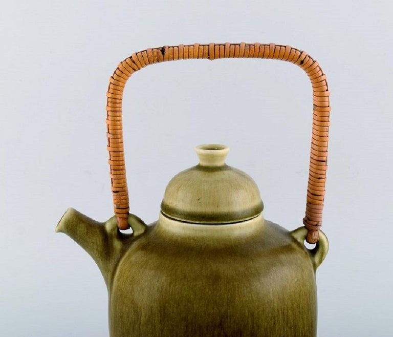 Frode Blichfeldt Bahnsen for Palshus. Teapot in glazed stoneware with wicker handle. 
Beautiful glaze in shades of green. 
1960s.
Measures: 26 x 18 cm (incl. Handle)
In excellent condition.
Stamped.