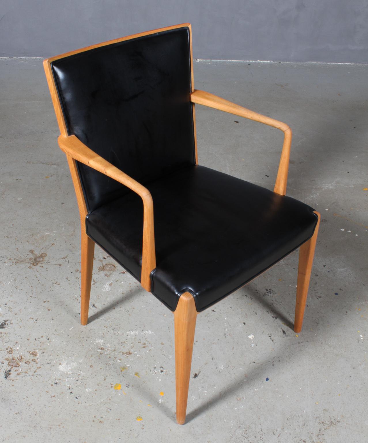 Frode Holm armchair with frame of elm.

Upholstered with black aniline leather.