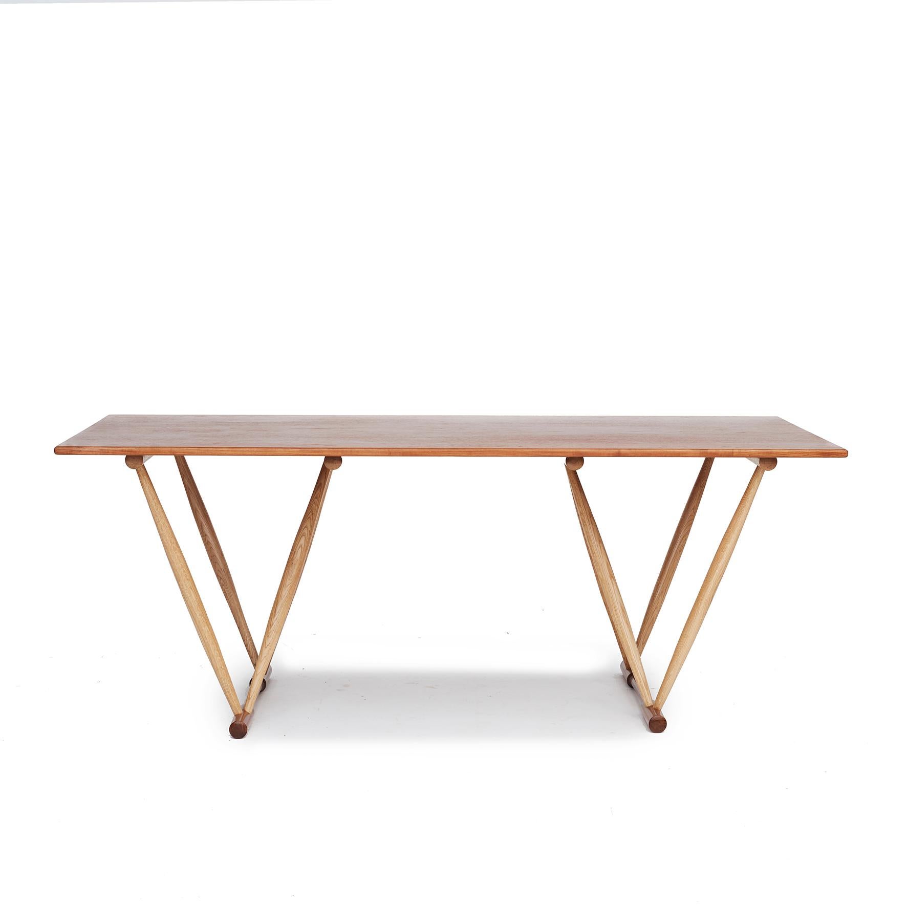 Frode Holm.
Work table / dining table with sculptural V-shaped frame and a rectangular top.

Table top in solid teak, legs in oak finished with teak floor stretchers.

Designed 1944. Manufactured for retailer Illums Bolighus.
Denmark 1960-1970.