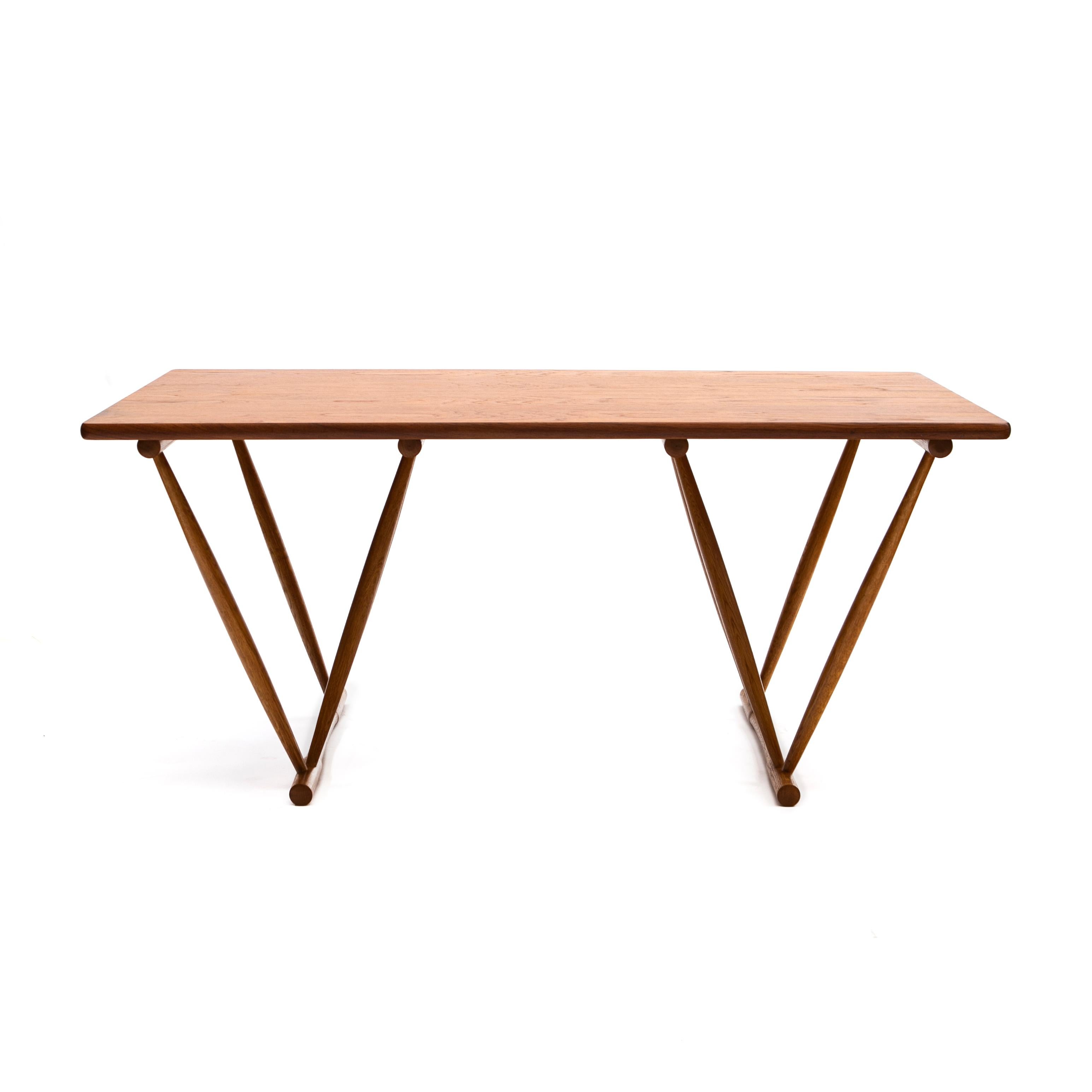 Frode Holm.
Work table / dining table with sculptural V-shaped frame and a rectangular top.

Table top in teak, legs in oak finished with teak floor stretchers.

Designed 1944.
Manufactured for retailer Illums Bolighus.
Denmark 1960-1970.