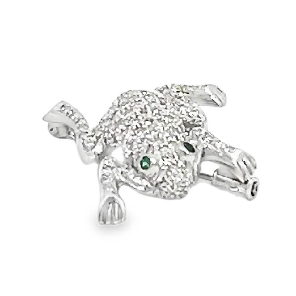 This 18K white gold frog brooch features diamond pavé detailing and emerald eyes, combining fine craftsmanship with a unique design. The brooch measures 3 cm x 3 cm and weighs 9.0 grams of solid 18K white gold. The brilliant-cut diamonds add