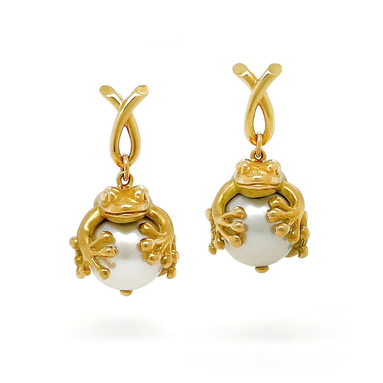 Valentin Magro Frog Grabbing a South Sea Pearl Earrings add whimsy tot he design. Both animals suspend from 18k yellow gold crossover loops. Rather than sit on lily pads, the frogs hug white South Sea pearls. The jewels' luster hints at their high