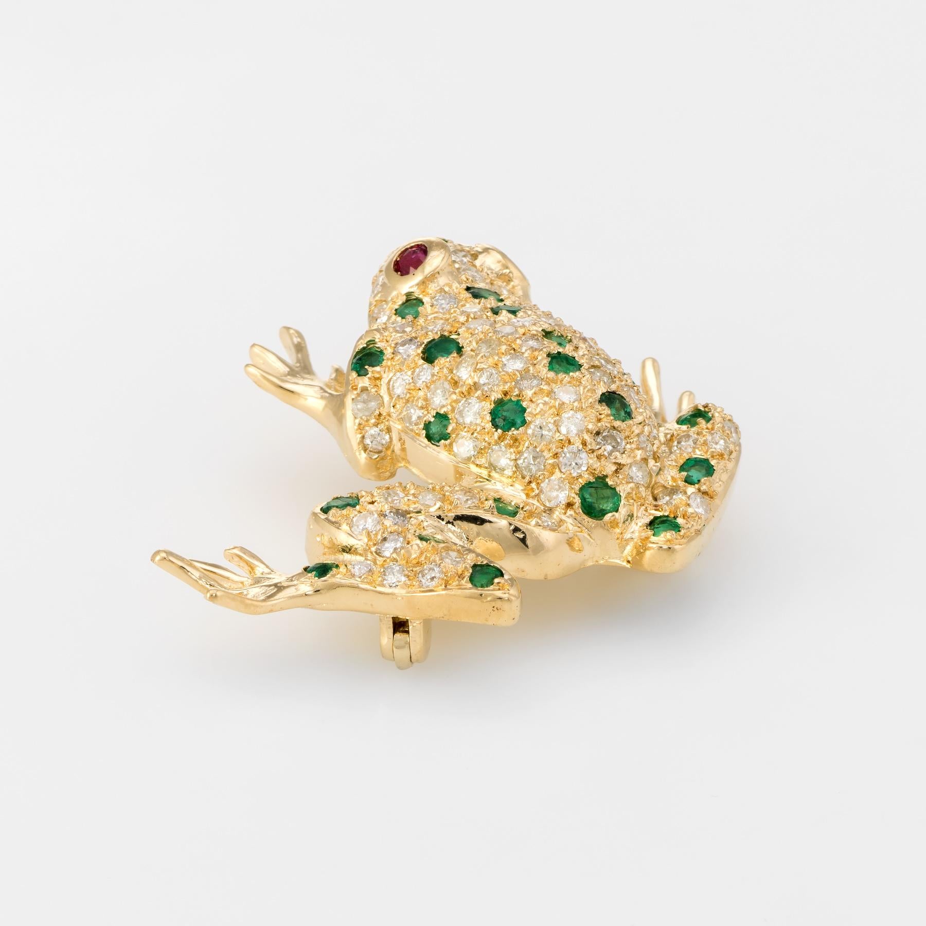 Finely detailed frog pendant (or brooch), crafted in 18 karat yellow gold. 

Emeralds total an estimated 0.23 carats, accented with an estimated 0.04 carats of rubies (embedded into the eyes). The diamonds are pave set into the body of the frog and