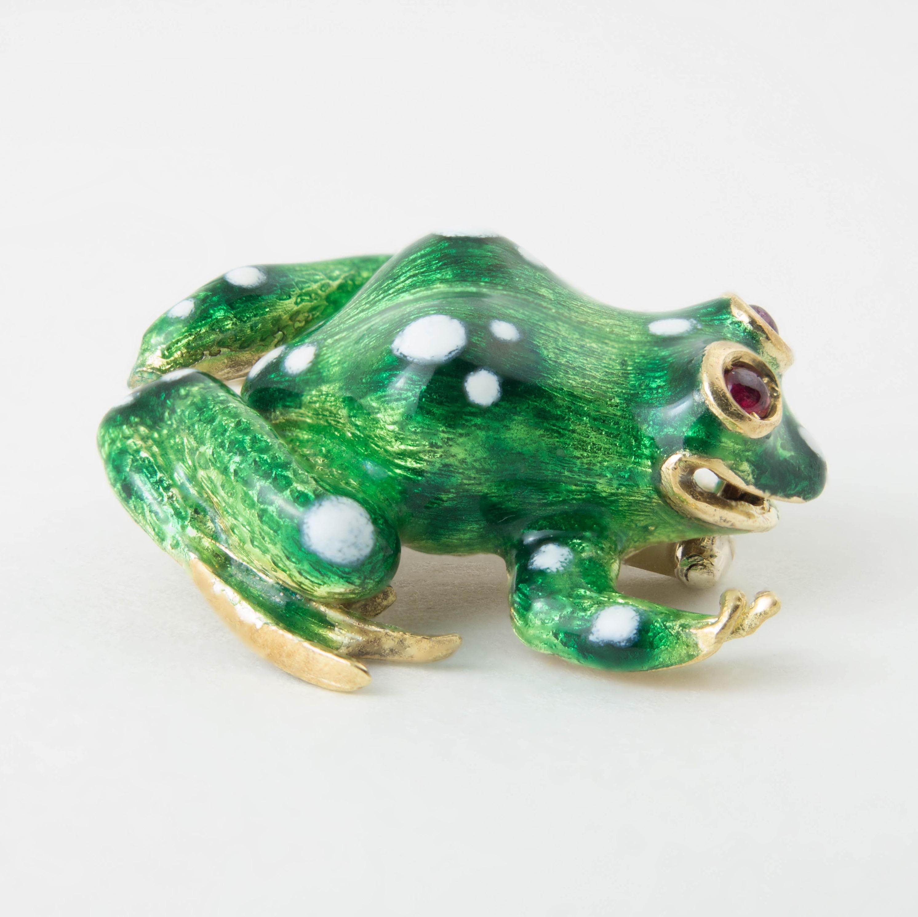 A delightfully charming 18k yellow gold, enamel and ruby frog pin or brooch, late 20th century.

The charming frog crafted in 18k yellow gold with a green enamel body with white enamel spots, and ruby cabochon eyes. 

Marked 