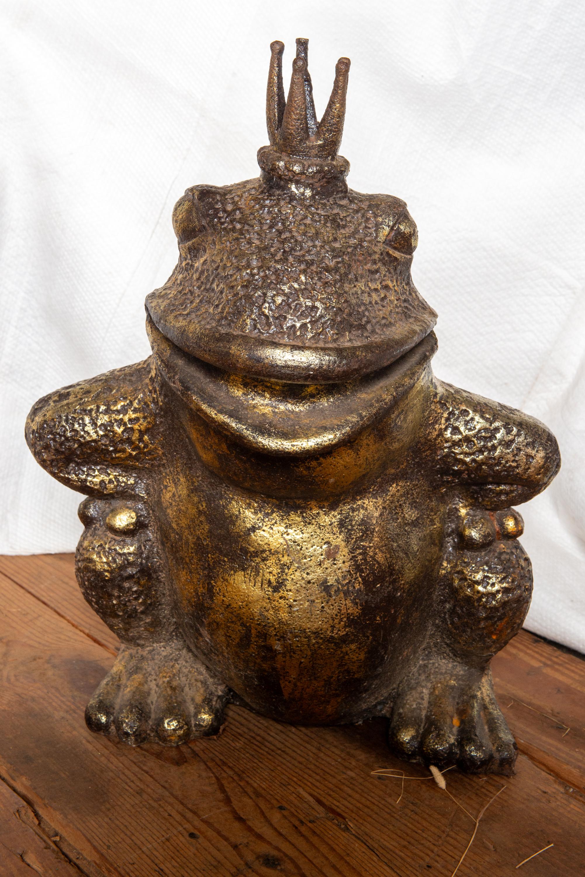 A fanciful gilt cast stone frog prince. He is croaching on his hind legs, wearing a crown and big smile. A fun addition to your garden or an indoor companion.
