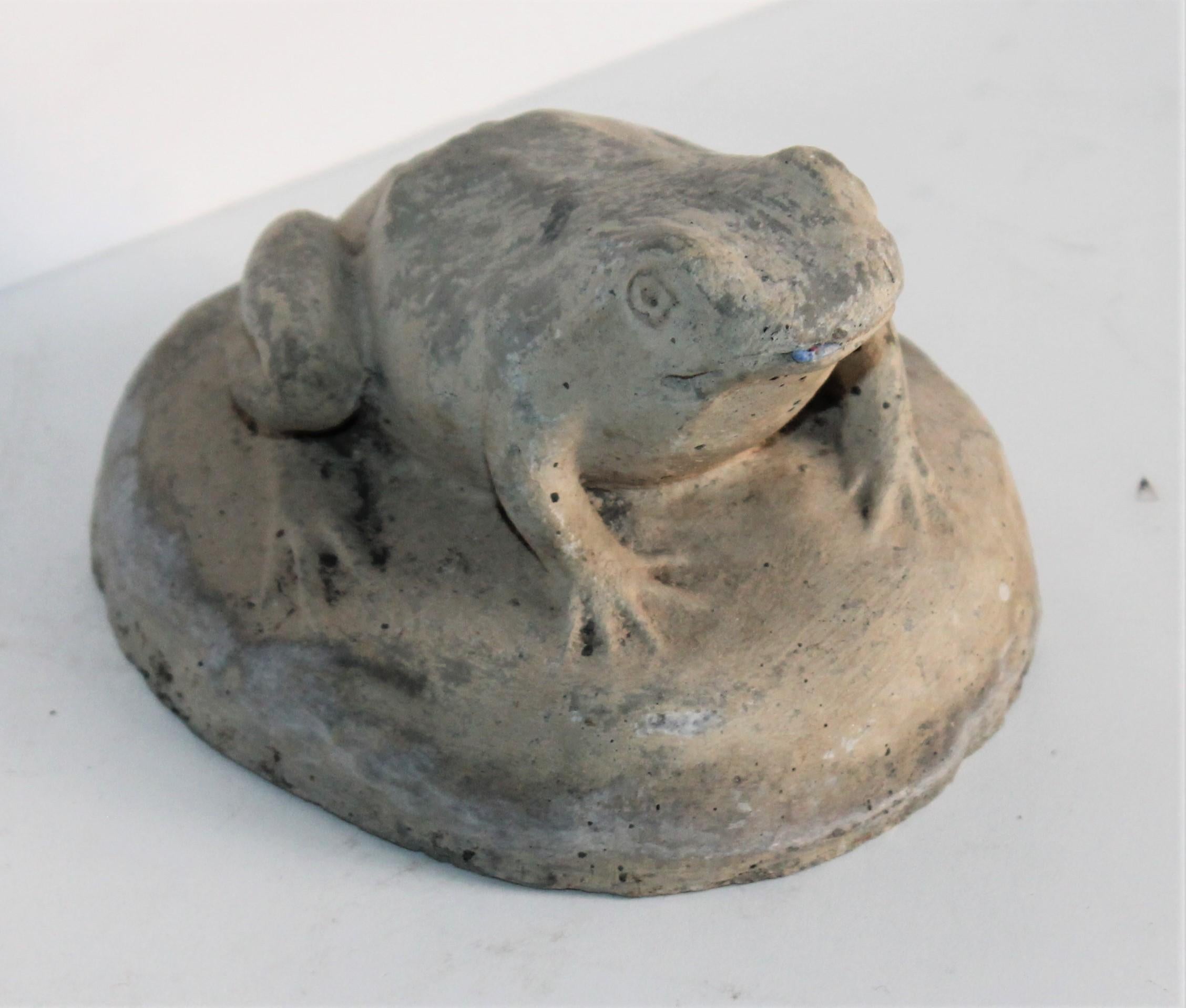 This fun handmade sculpture of a frog is in good condition with minor nicks on the edge consistent from age and use.