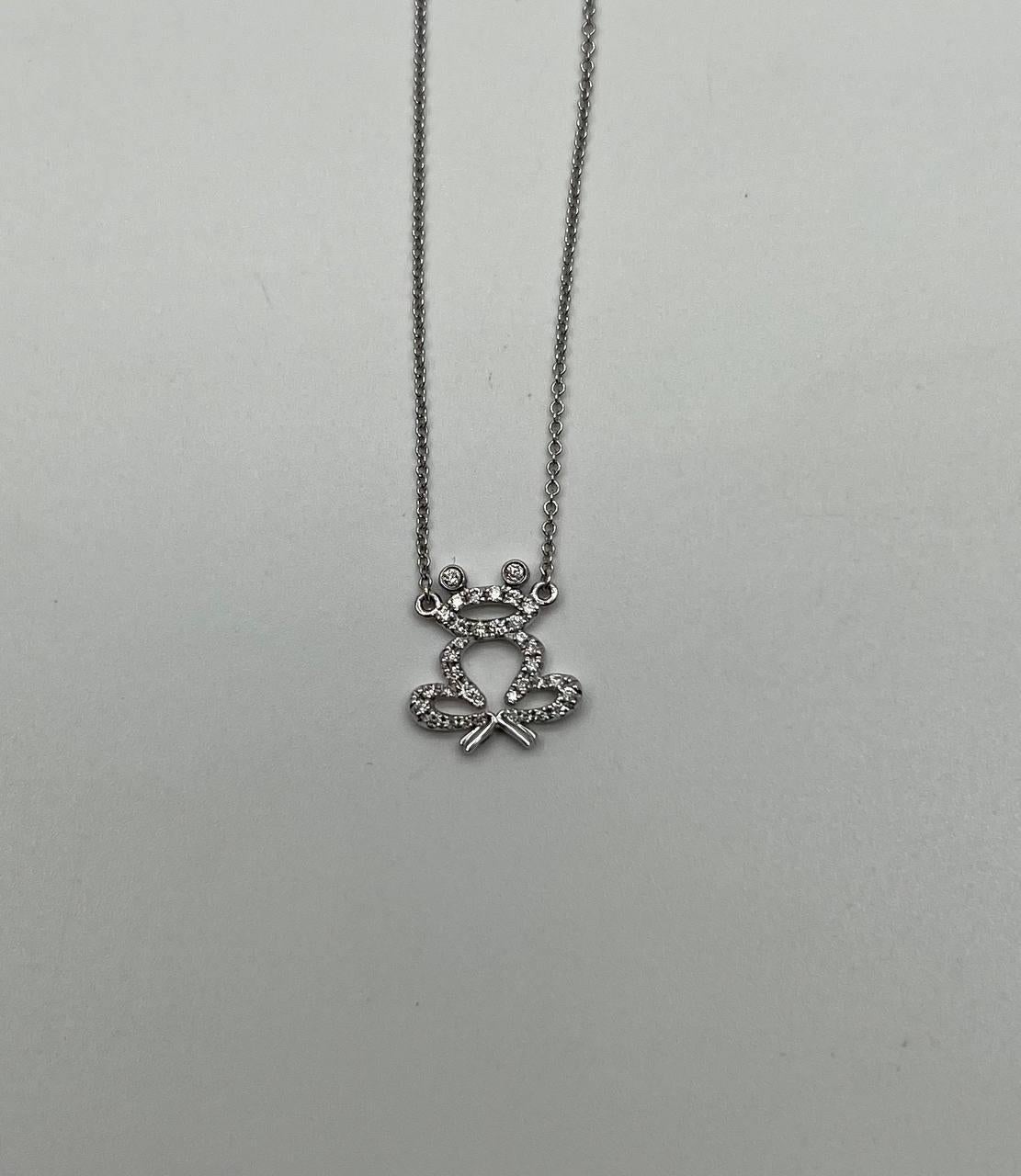 Ce collier à pendentifs fantaisiste est réalisé en or blanc 18 carats. Le pendentif présente un motif ludique de grenouille, orné de diamants blancs totalisant environ 0,25 carats.
Le corps de la grenouille est souligné de diamants étincelants,