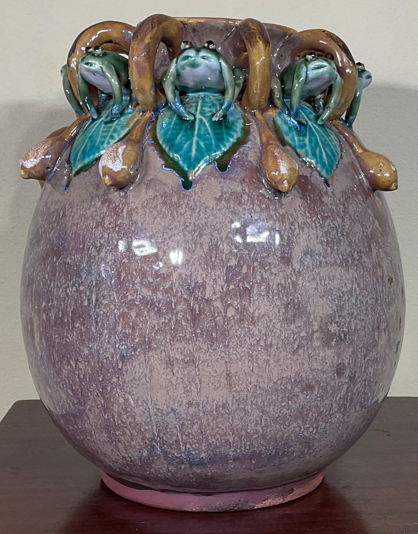 Beautiful hand made vase made of ceramic hand painter with a group of frogs surrounded the rim.
great object of art for display.