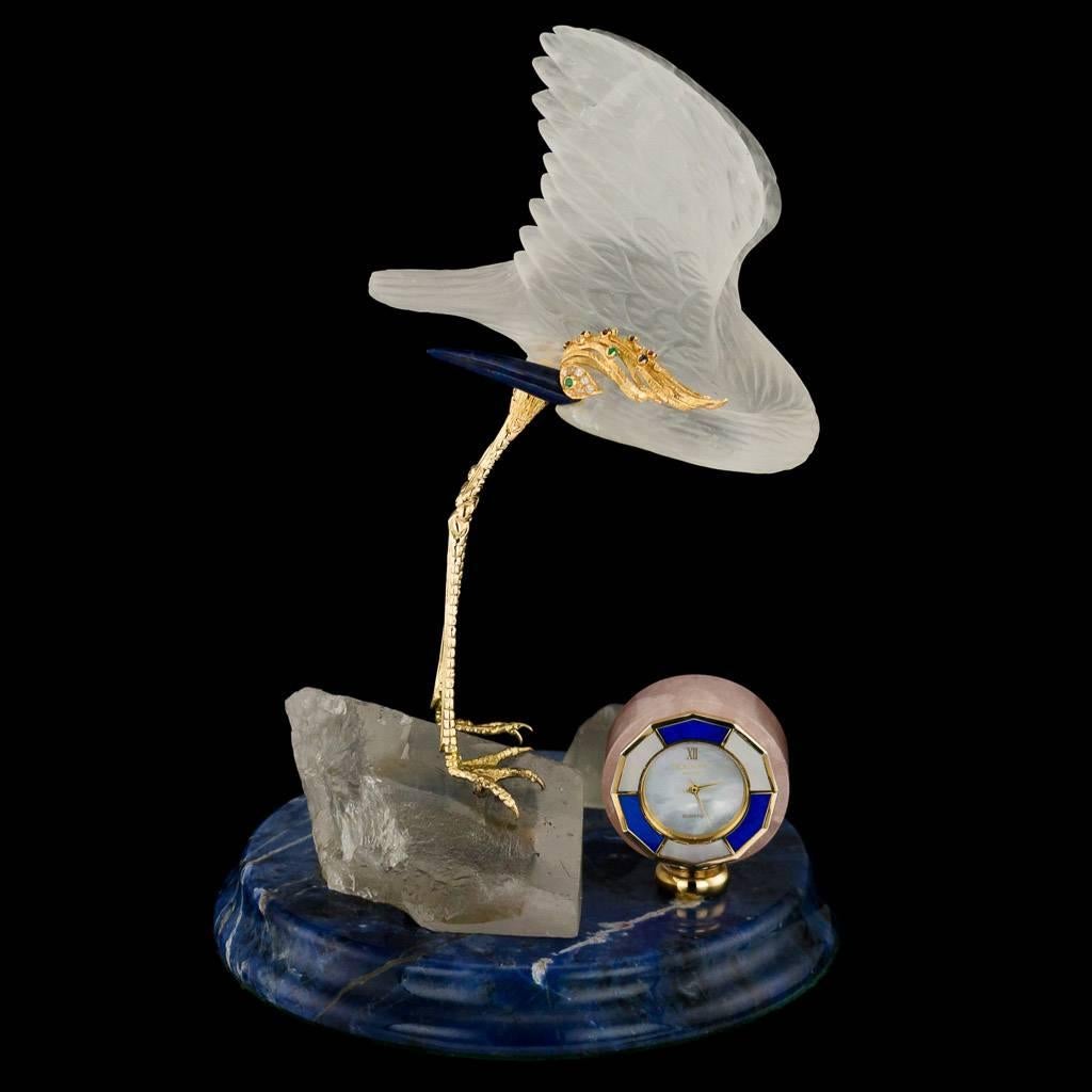 Stunning 20th century Belgian (Antwerp), gem set desk clock, modeled as a rock crystal stork, head mounted in gold and set with a diamonds, emeralds, sapphires and rubies with a lapis lazuli beak and with a rose quartz clock to the lapis lazuli