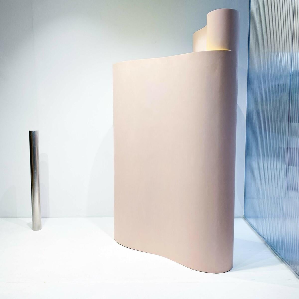 La scultura da pavimento *Dal passato al presente* di Govert Heikoop (1988) presenta forme geometriche audaci e un sottile gioco di toni tenui di rosa, verde e bianco. Le tinte pastello interagiscono in modo dinamico con la luce, proiettando ombre e