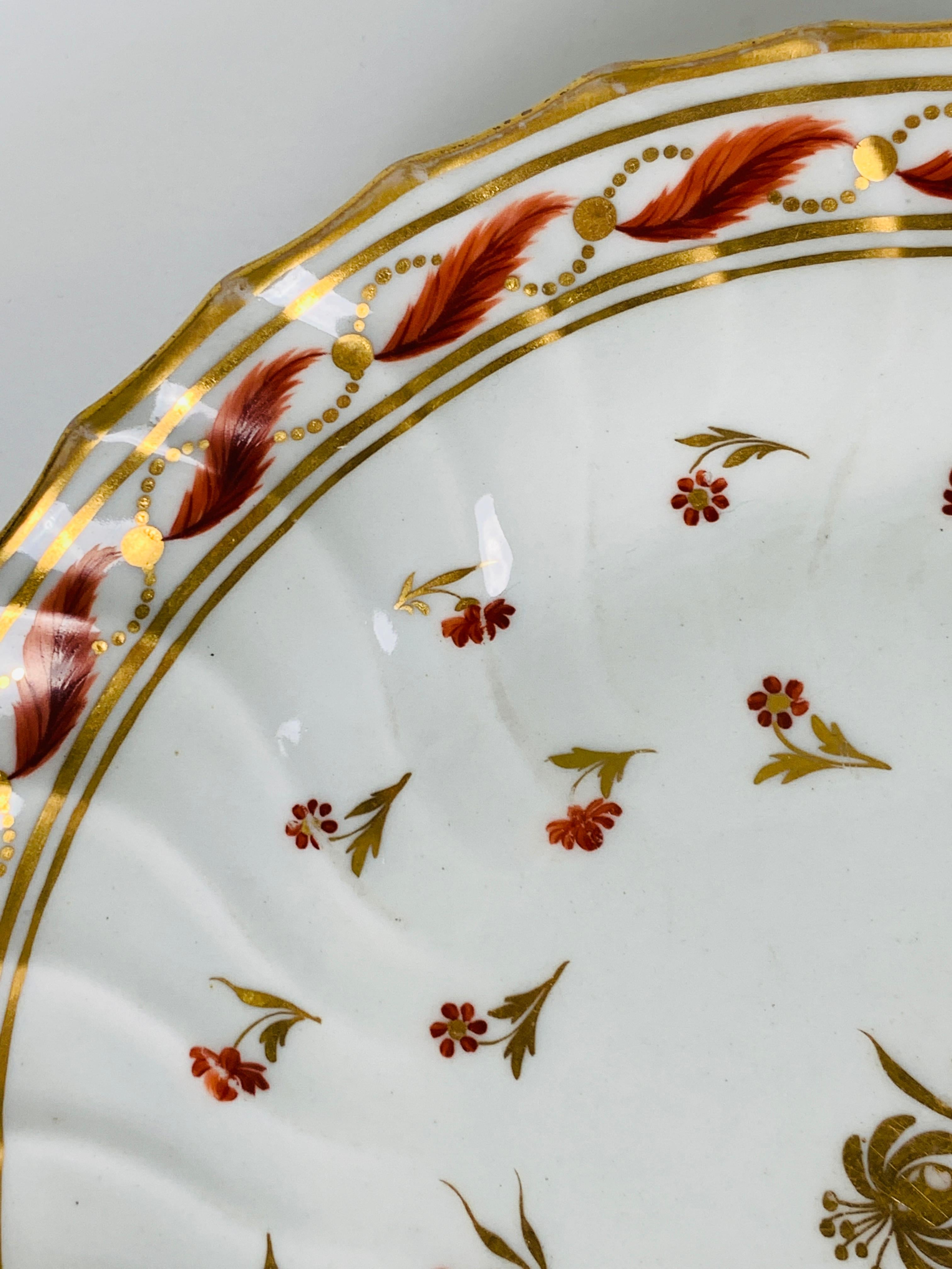 Provenance: The Private Collection of Mario Buatta
Made in England circa 1820, this elegant and beautiful saucer dish has fluting, which seems to form ripples in the porcelain. 
It is decorated with a single gold flower in the center, surrounded by