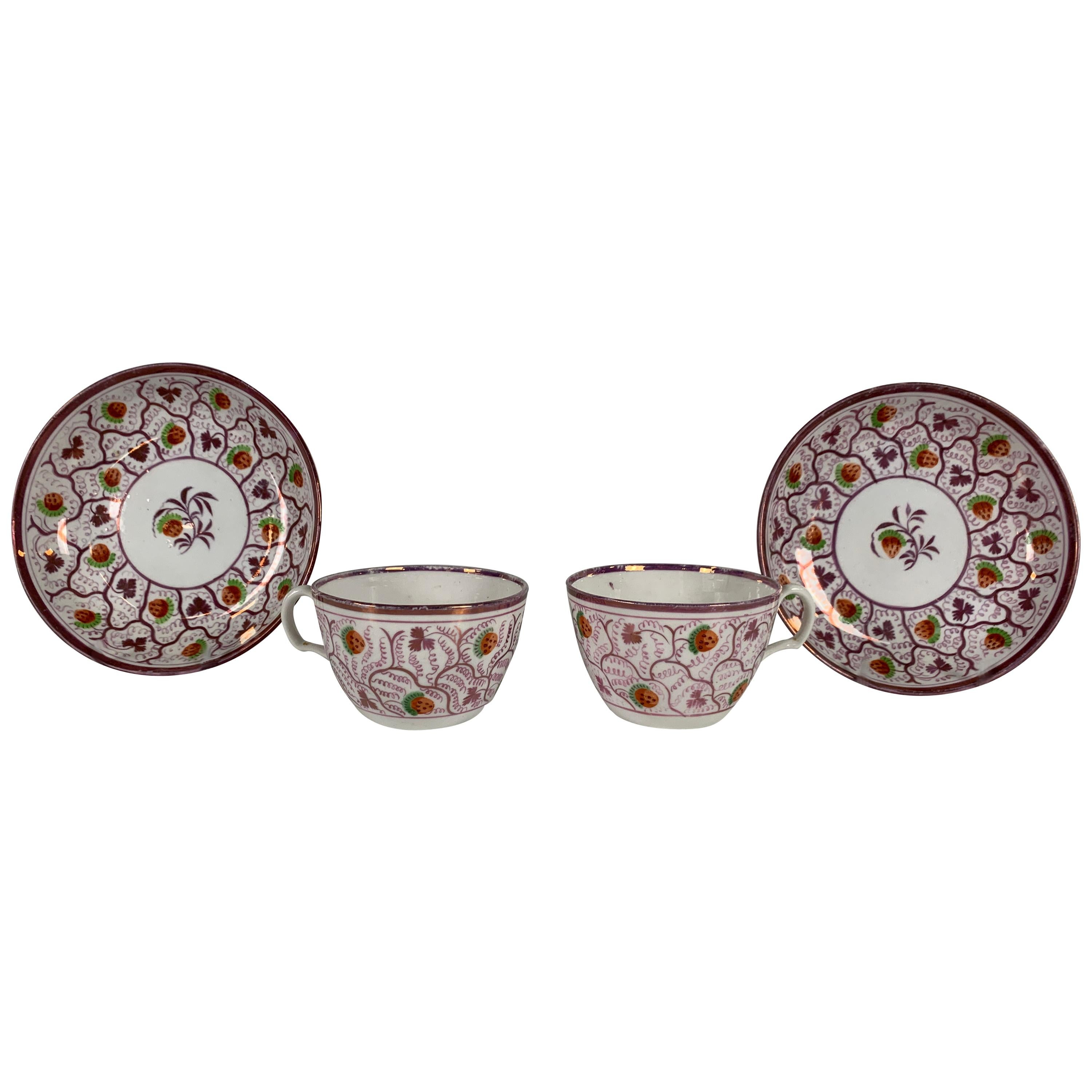 From the Collection of Mario Buatta a Pair of Pink Lustre Cups and Saucers