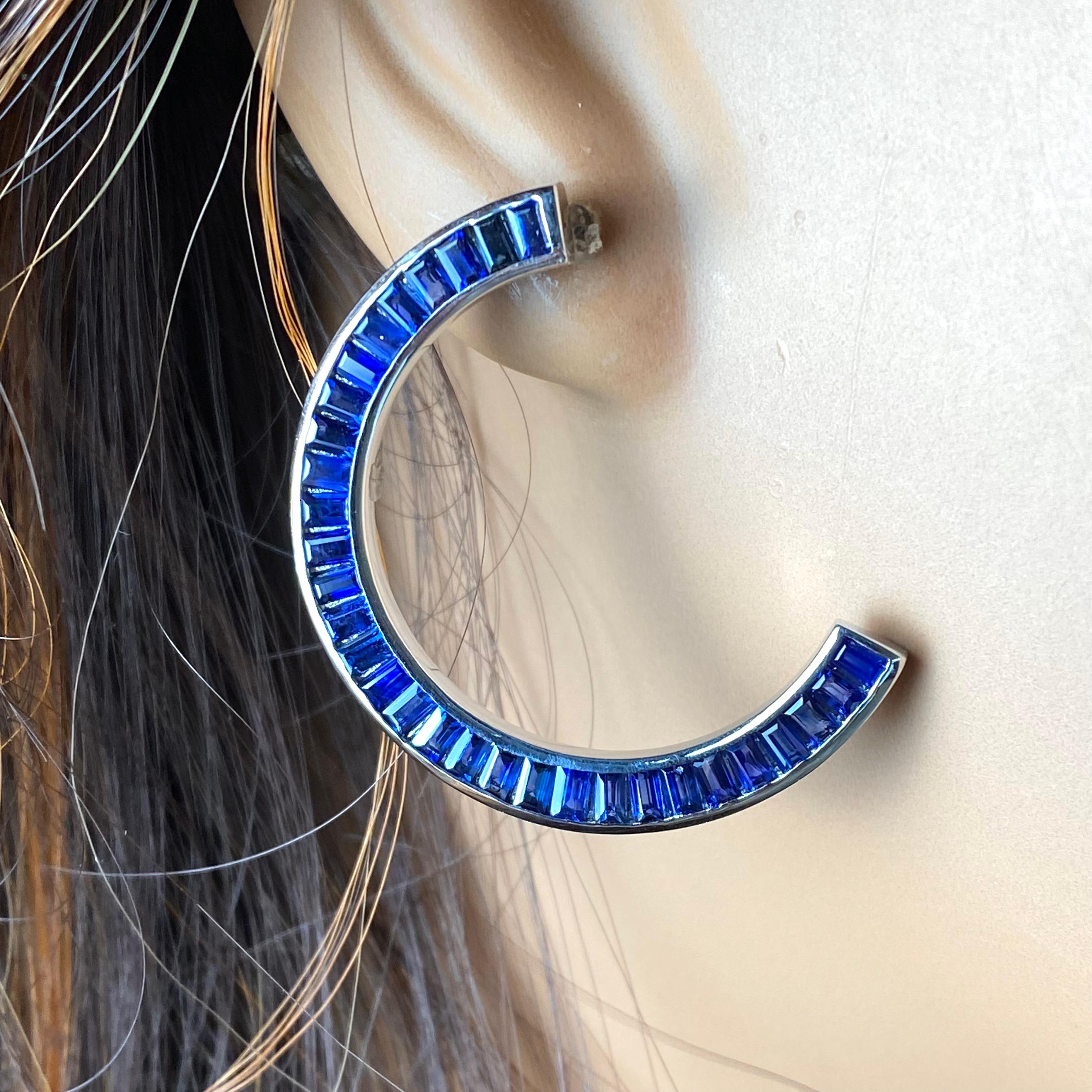 Introducing our exquisite 14 karat white gold front-facing half moon earrings, adorned with a mesmerizing array of 62 perfectly matched baguette sapphires, totaling a stunning 8.30 carats. Crafted to epitomize elegance and sophistication, these