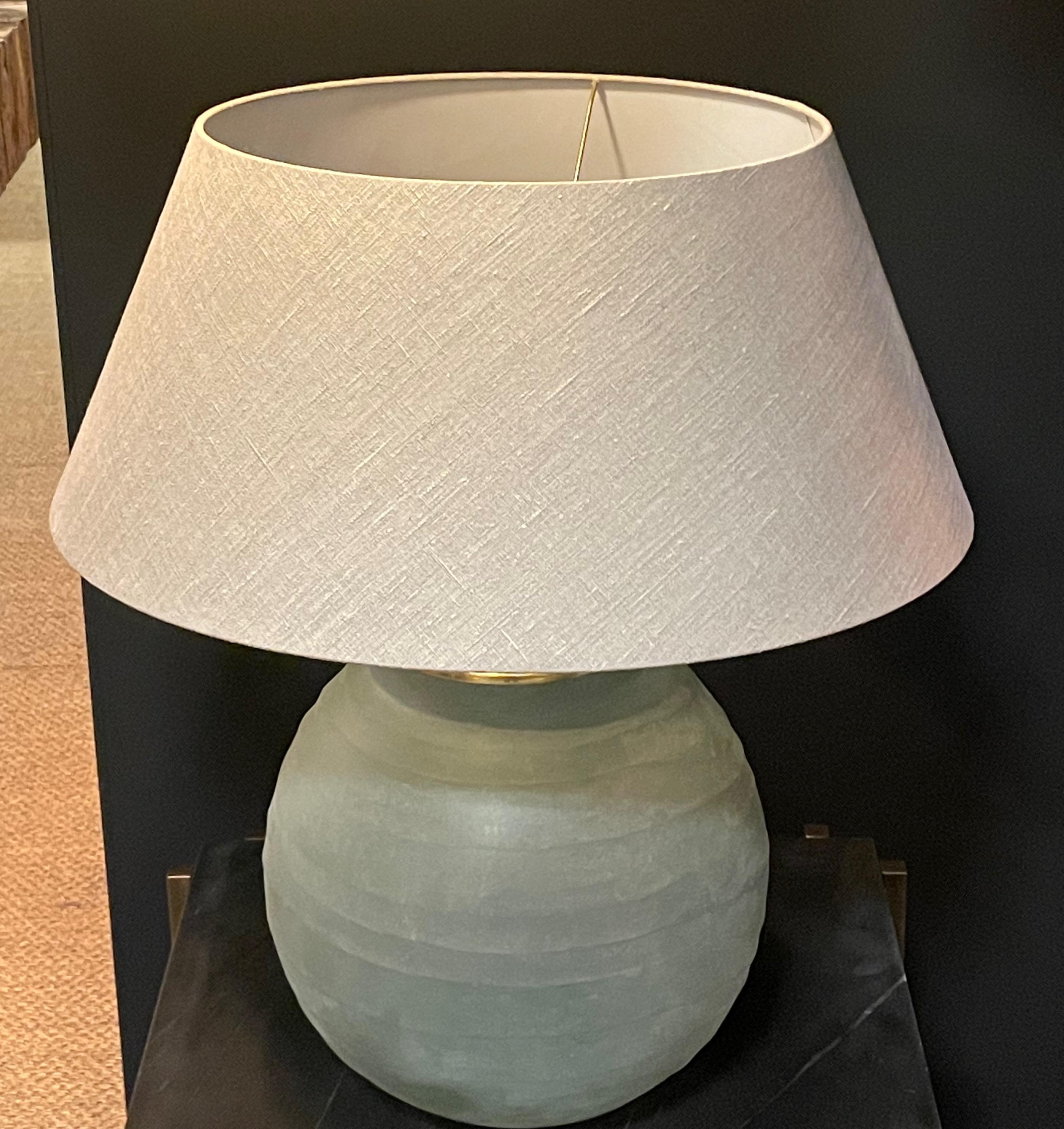 Contemporary Romanian pair of frosted blue glass lamps with 
horizontal ribbed detail.  The frosted blue glass base is reminiscent of sea glass.
Lamp base measures: 13