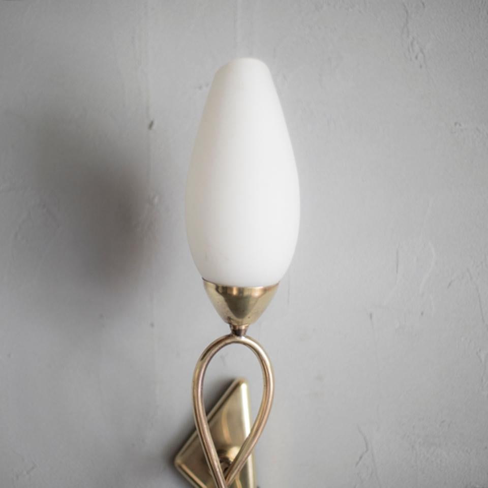 Midcentury frosted glass and brass wall lamp in Stilnovo style.
Warm light through the frosted glass and the beautiful metal work will decorate your home wonderfully.
 