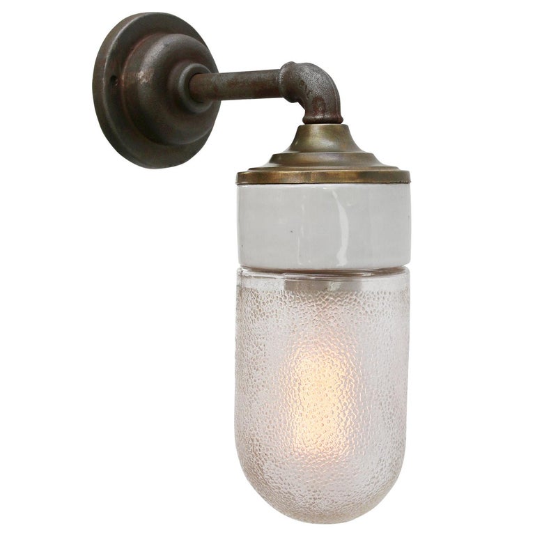 Porcelain Industrial wall lamp.
White porcelain, brass and cast iron
Frosted glass.
2 conductors, no ground.

Diameter cast iron wall piece 10 cm. 2 holes to secure.

Weight: 1.95 kg / 4.3 lb

Priced per individual item. All lamps have been