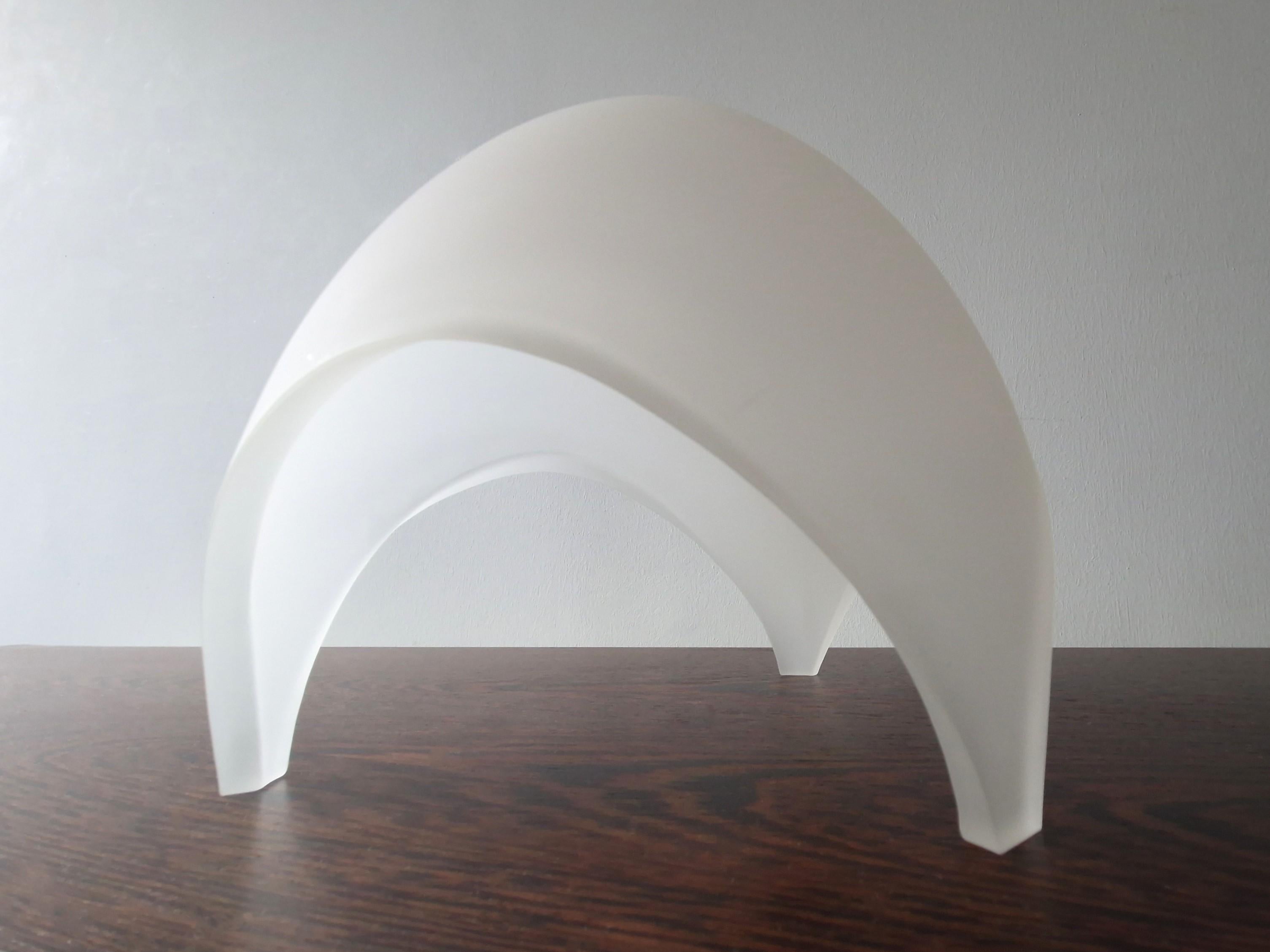 Cette fantastique lampe de table, modèle 'Coque', a été réalisée pour Martinelli Luce et s'inspire de la nature et de la géométrie. Le verre dépoli et la forme de dôme créent une belle lumière douce dans votre pièce. Il est marqué par Martinelli
