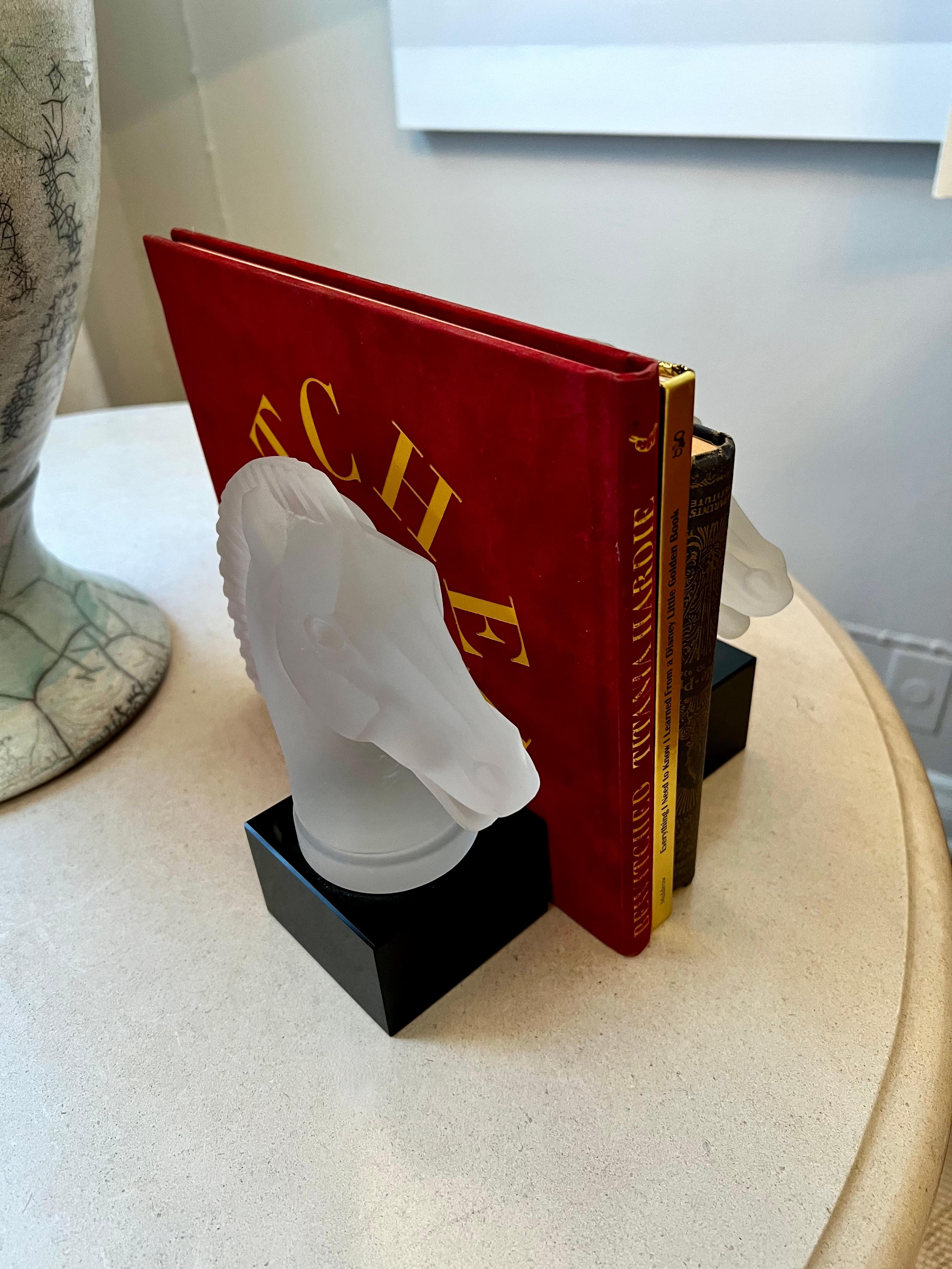 Pair of Solid glass Horse head bookends with solid black glass base. The pair are wonderful and are very reminiscent of Lalique. Very sophisticated at over 2 pounds each - heavy and substantial. could be used purely as decorative flanking a mantle,