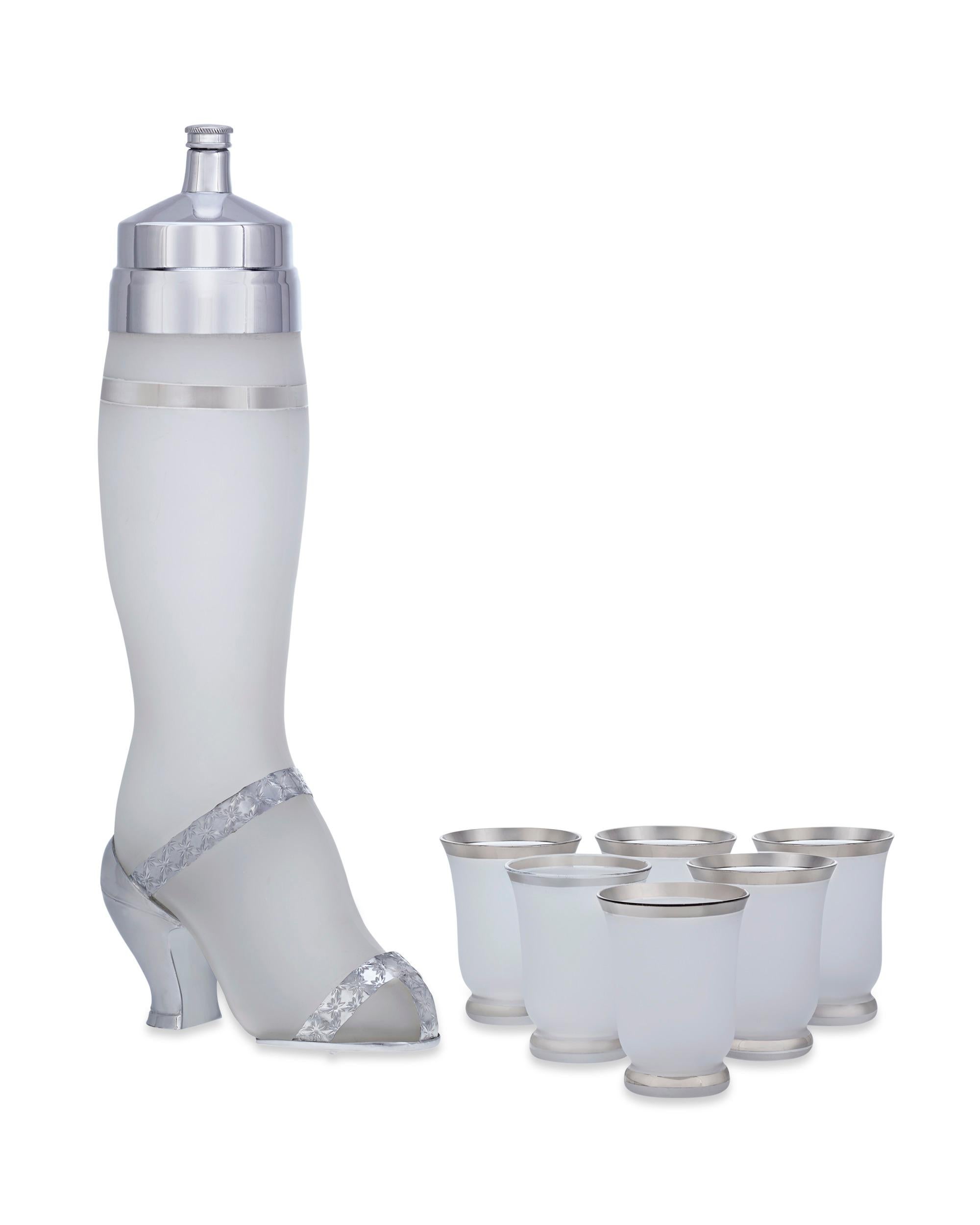 Playful and provocative, this cocktail shaker by West Virginia Specialty Glass Co. takes the form of a lady's leg. The leg is crafted of frosted glass and is accessorized with a silverplate dancing shoe. A silverplate lid tops the shaker, and it