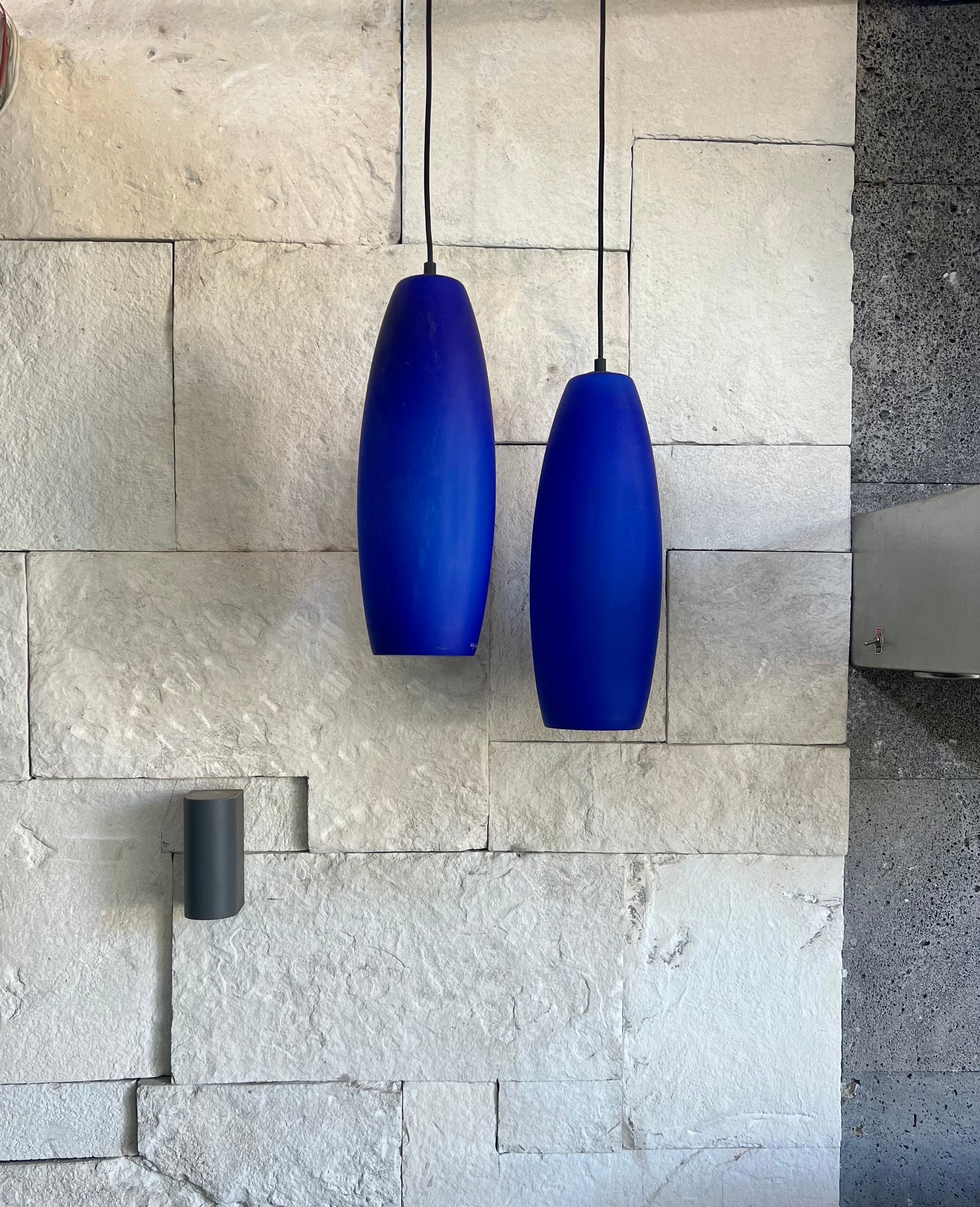 Lot de deux suspensions en verre satiné givré bleu
Les deux verres ont une couche intérieure blanche.
Fabriqués à Murano, Italie, au début des années 70, par De Majo Murano, les deux pendentifs sont signés 