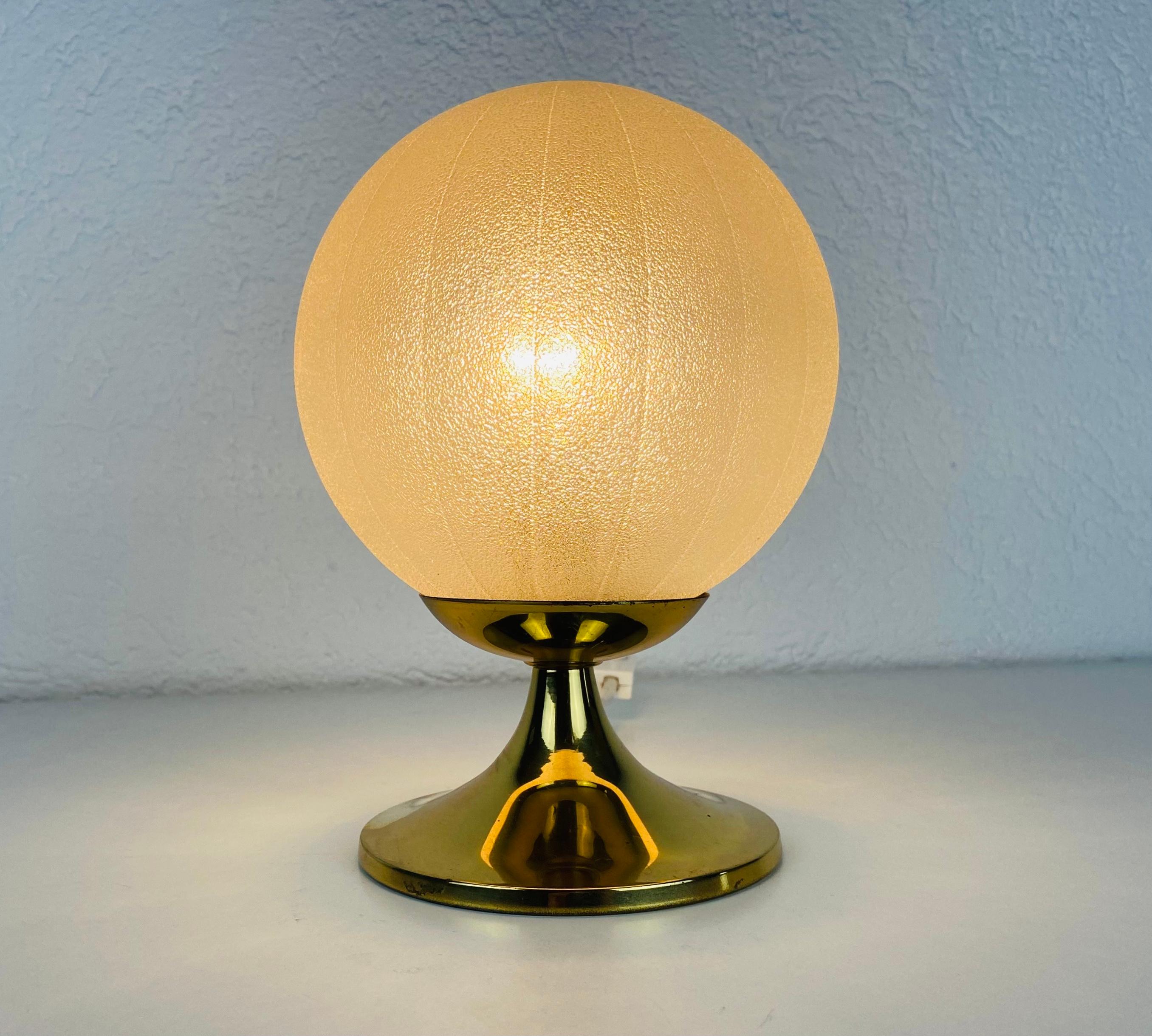 A beautiful table lamp by Doria made in Germany in the 1970s. It has a brass base and the glass shade is made of frosted ice glass. It is in very good vintage condition.

The light requires one E14 light. Works with both 120V/220V.

Free