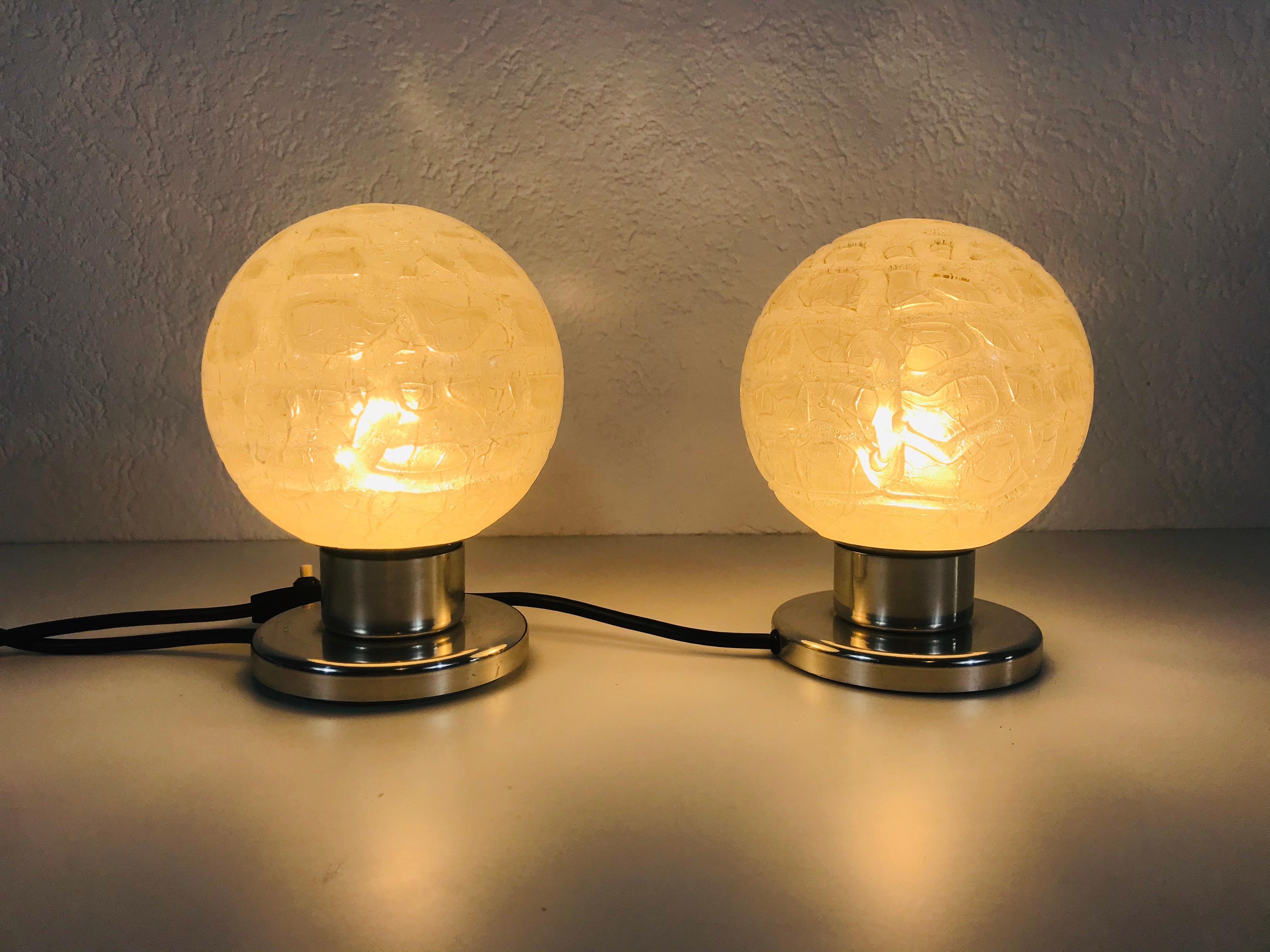 A beautiful pair of table lamps by Doria made in Germany in the 1970s. They have a brass base and the glass shades are made of frosted ice glass. They are in very good vintage condition.

The light requires one E14 light bulb.
