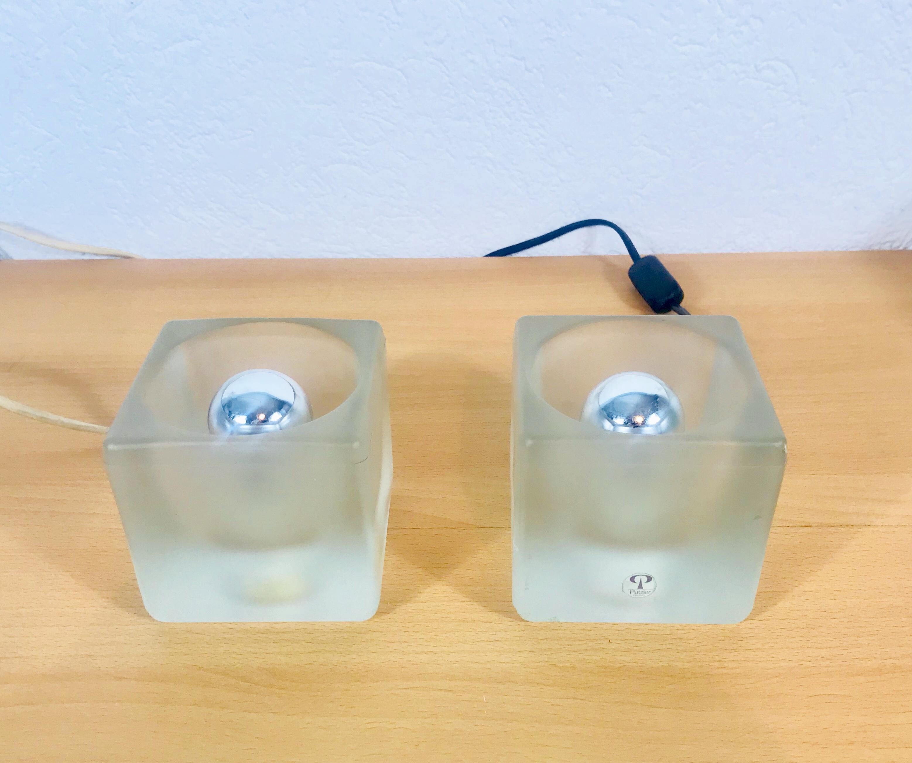 A beautiful pair of table lamps by Peill & Putzler made in Germany in the 1970s. They have a cube shape and are made of frosted ice glass. The original brand label is on one of the lights. They are in very good vintage condition.

The light