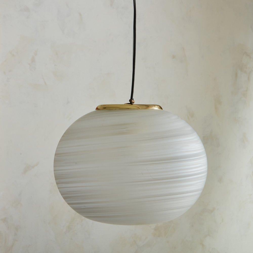 A 1950s Italian pendant featuring a handblown Murano frosted glass globe with white swirl detailing. This pendant has brass hardware and hangs from the original brass canopy with a black cord and wire tension support. Unmarked. Sourced in Italy,