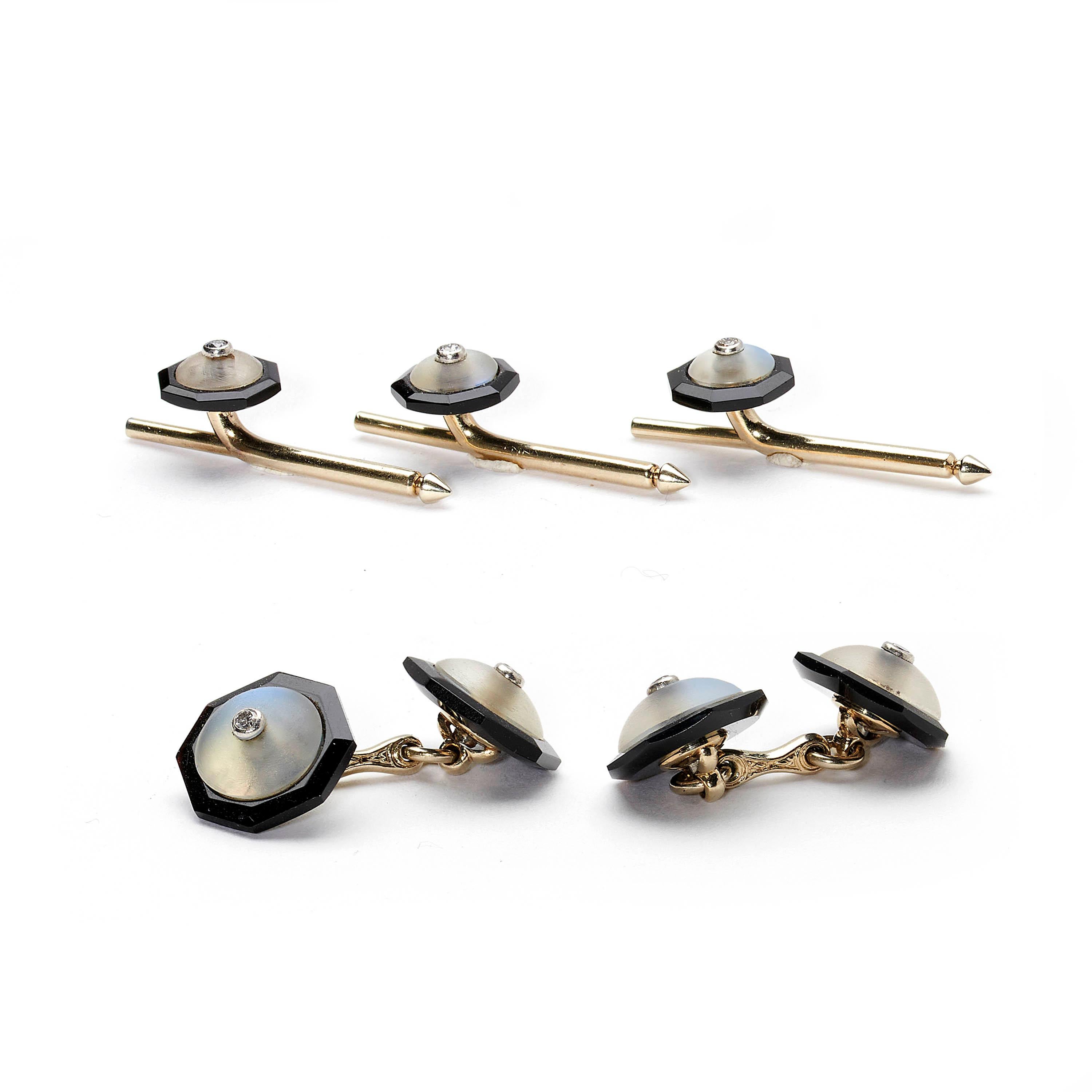 A frosted rainbow moonstone and black onyx dress-set, comprising of a pair of cufflinks and three studs, with rub-over set diamonds in the centres, surrounded by domed frosted rainbow moonstone, set in octagonal black onyx, with yellow gold