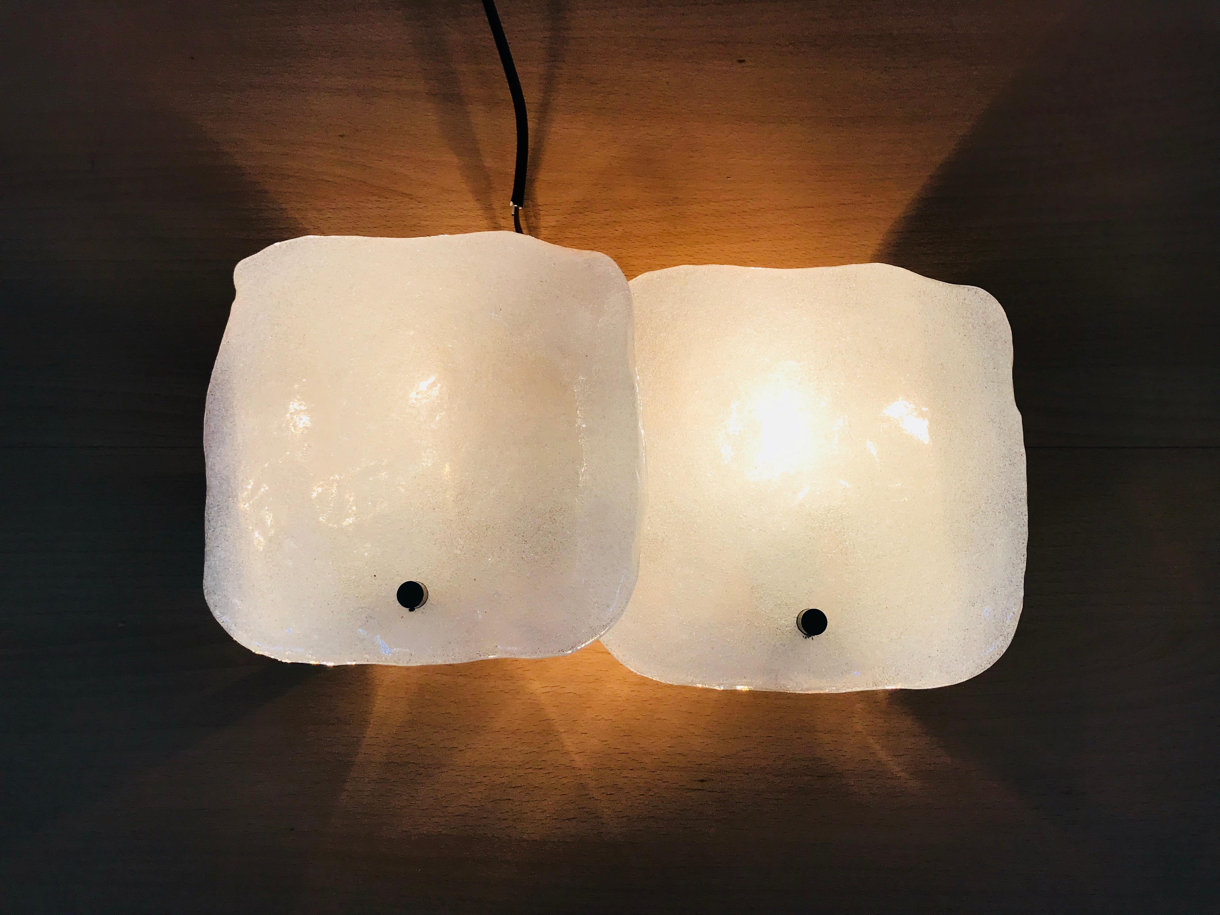 Amazing wall lamp by the Austrian brand Kalmar Franken made in the 1960s. Two Square frosted ice glasses secure to the chrome aluminum frame. There are two sockets which require E14 light bulbs.