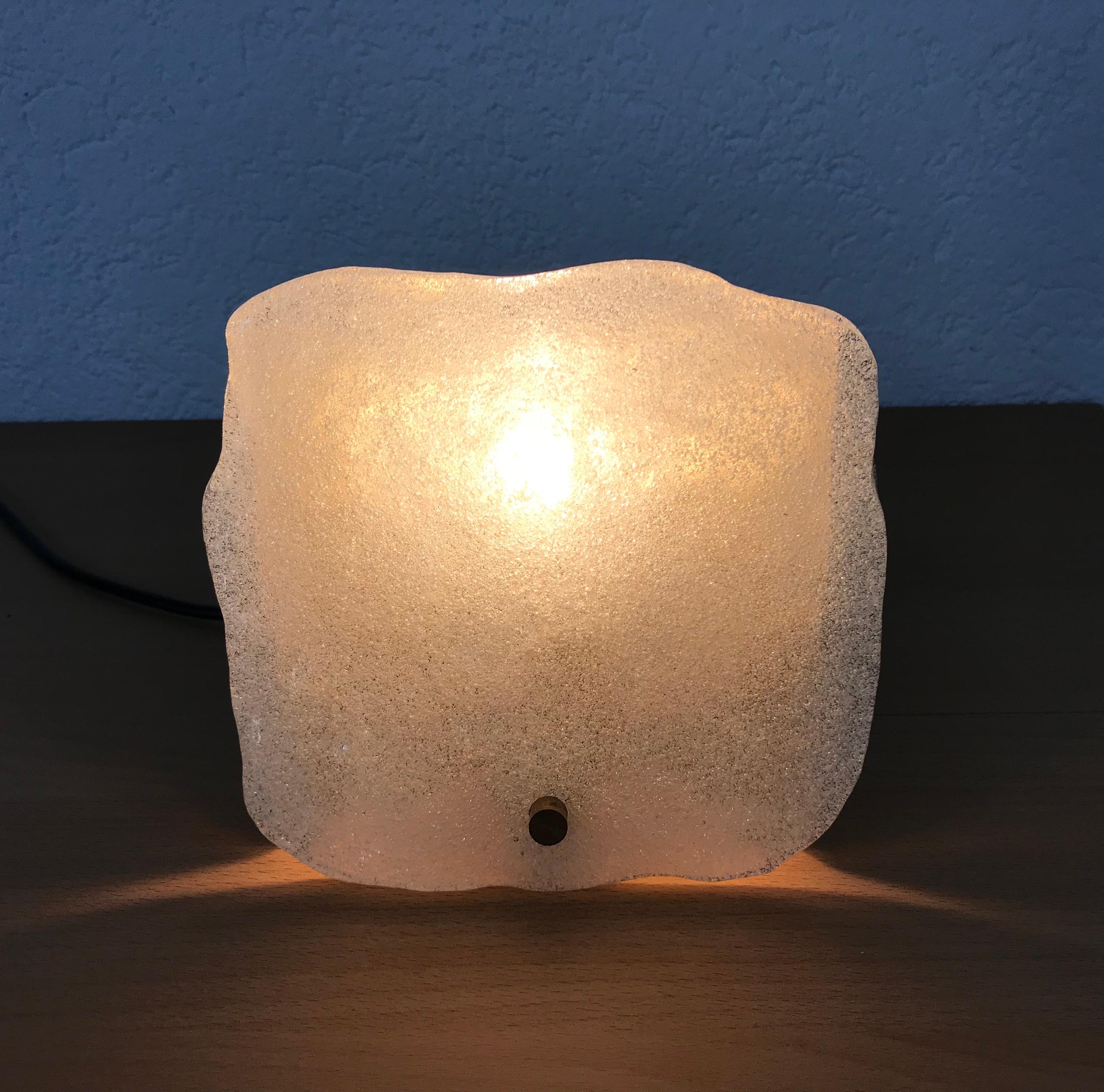 Amazing wall lamp by the Austrian brand Kalmar Franken made in the 1960s. Square frosted ice glasses secure to the golden aluminum frame. 

The light requires one E14 light bulb.