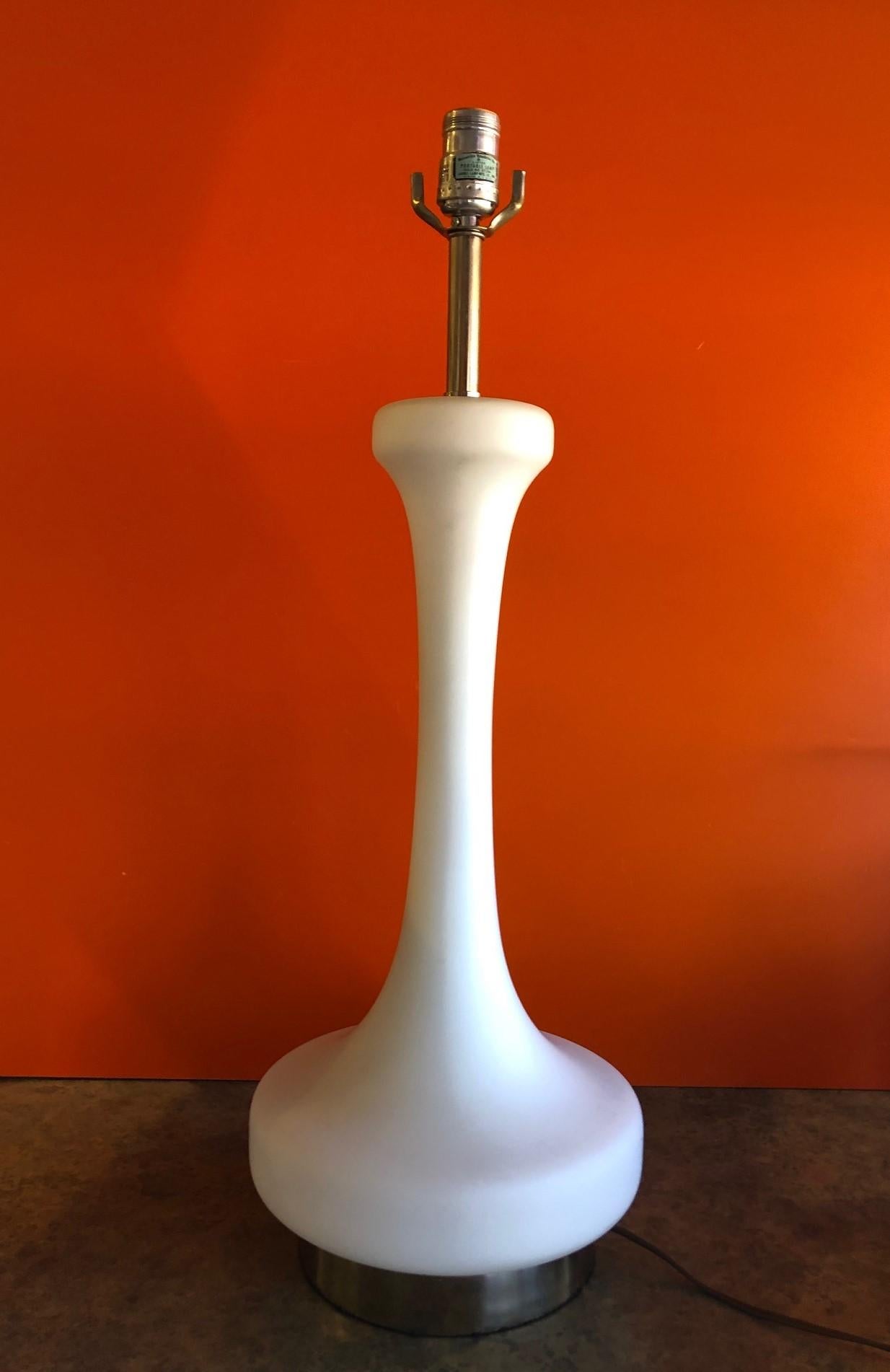 Frosted white glass lamp with lighted base by Laurel Lamp Co, circa 1960s. The piece has an interior illuminated base that can be turned on and off that sits on a chrome base. This is a very cool and rare piece!