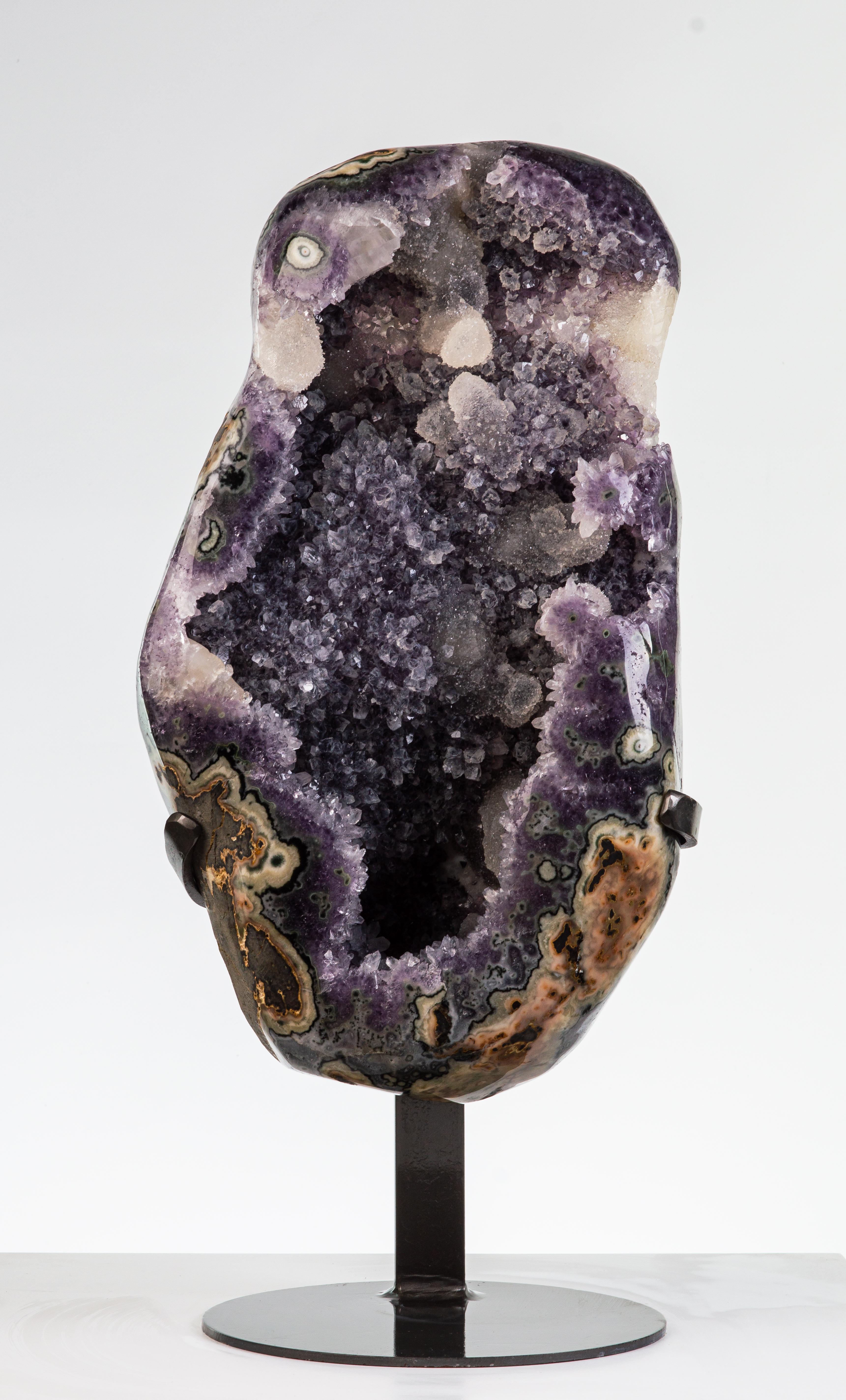 A beautiful amethyst cluster with polished borders revealing multiple agatised
layers. The interior of this specimen has a wonderful frosty appearance with
purple amethyst, creamy calcites and white quartz.

This piece was legally and ethically
