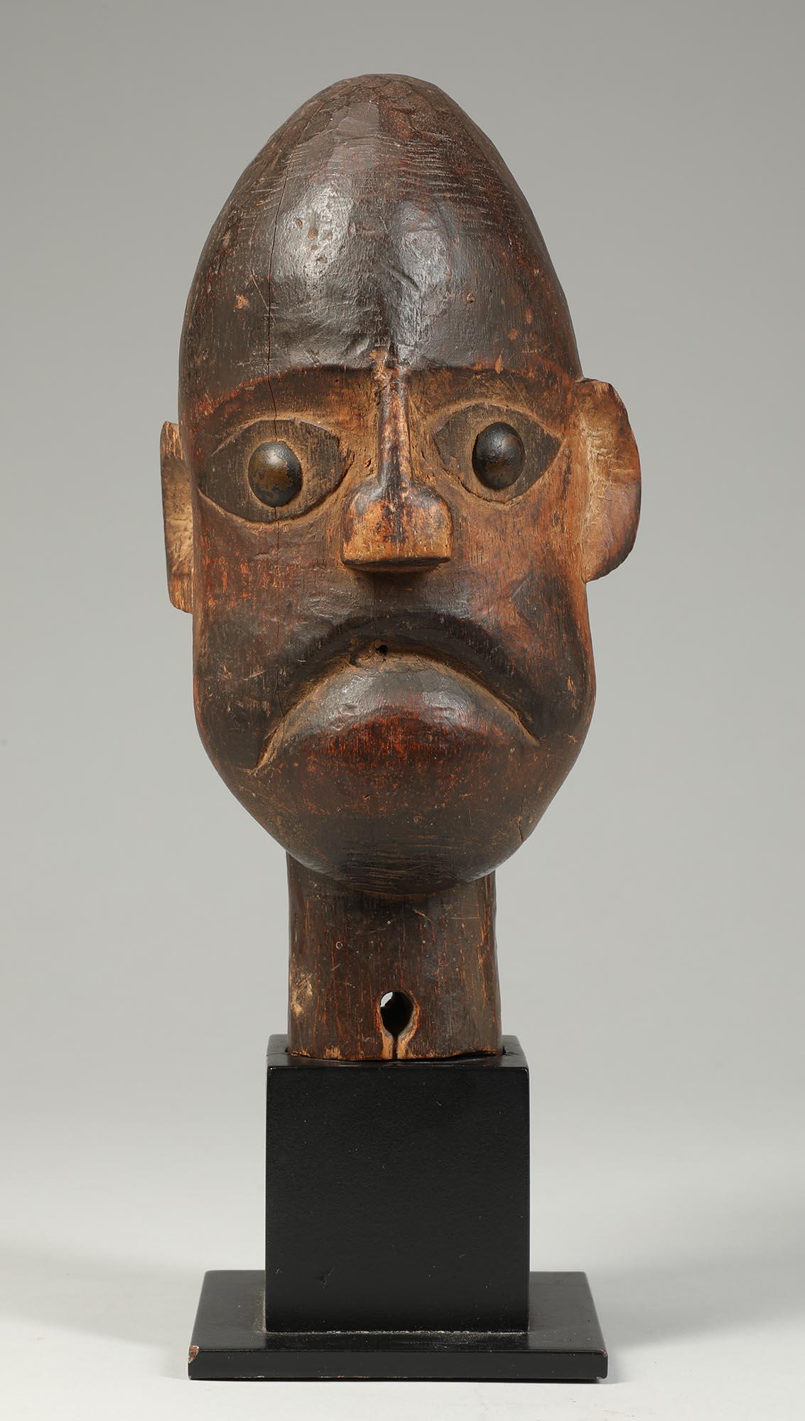 Early Ibibio puppet head with strong stern expression through tightly closed lips, large brass tack eyes. With wood tenon mounted in custom base. 
Total height on base 11 1/4 inches
Field collected in Ghana in 2002.
color is more accurate in the