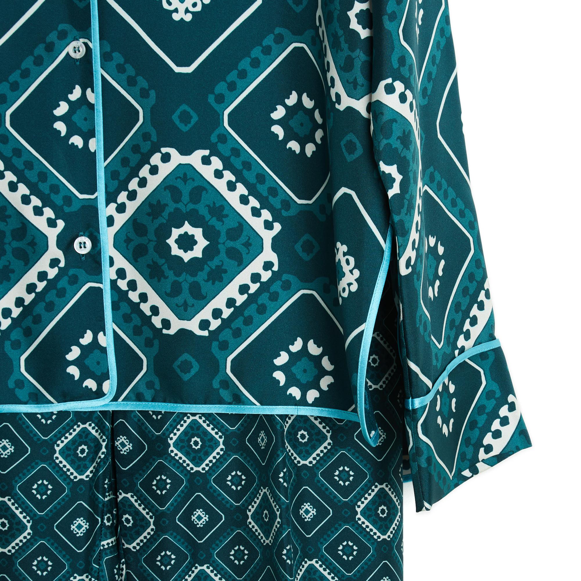 Conjunto F.R.S. For Restless Sleepers de sarga de seda en tonos verdes y crudos con motivos geométricos y ribeteado con una cinta de seda verde en contraste. El conjunto se compone de un top, que puede utilizarse como blusa o chaqueta, con cuello