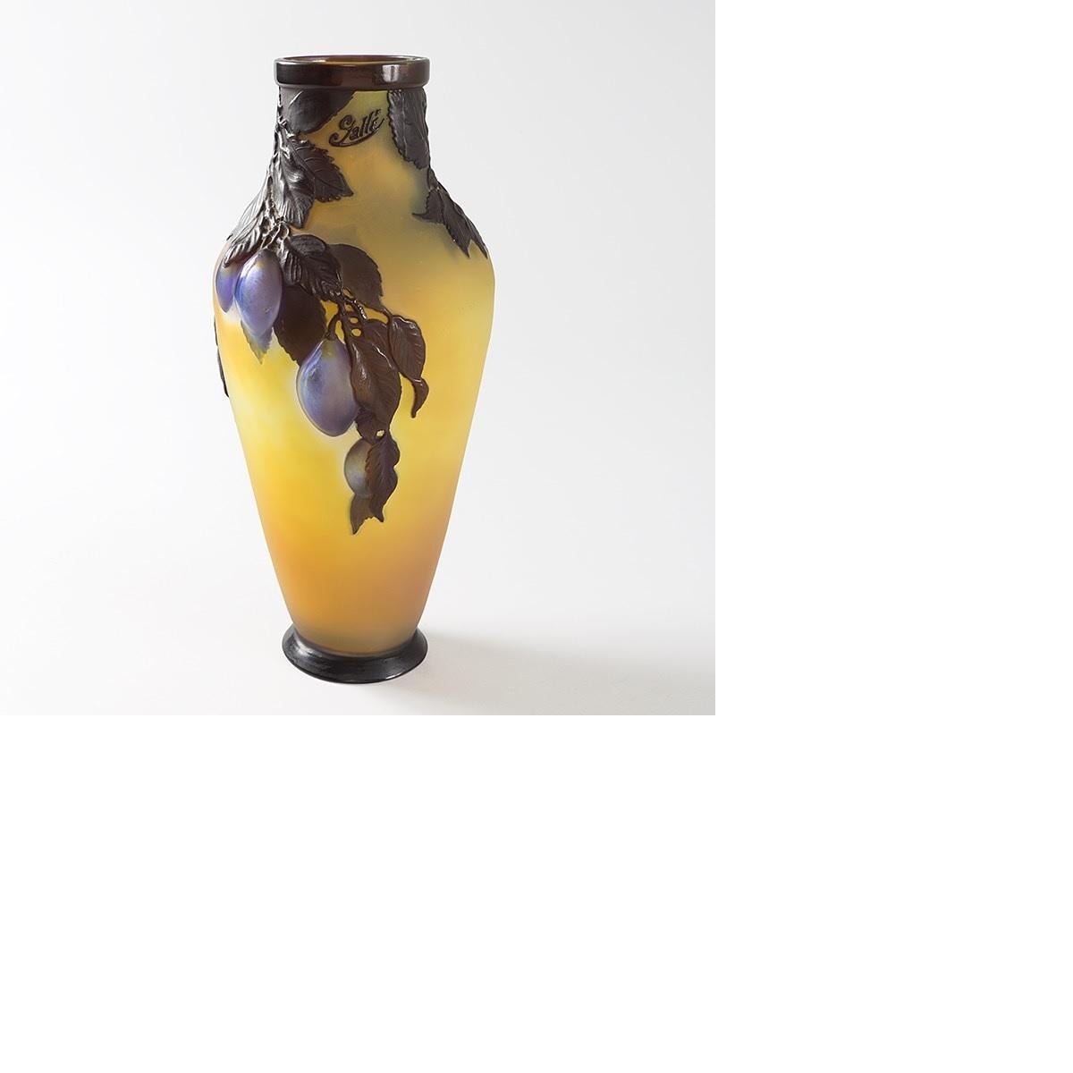 A French Art Nouveau mold blown cameo glass “Plum” vase by Emile Gallé. The applied blue and yellowish burgundy fruits rest on brown leaves, all on a yellow ground. 

A similar vase is pictured in: “Glass by Gallé”, by Alastair Duncan and Georges