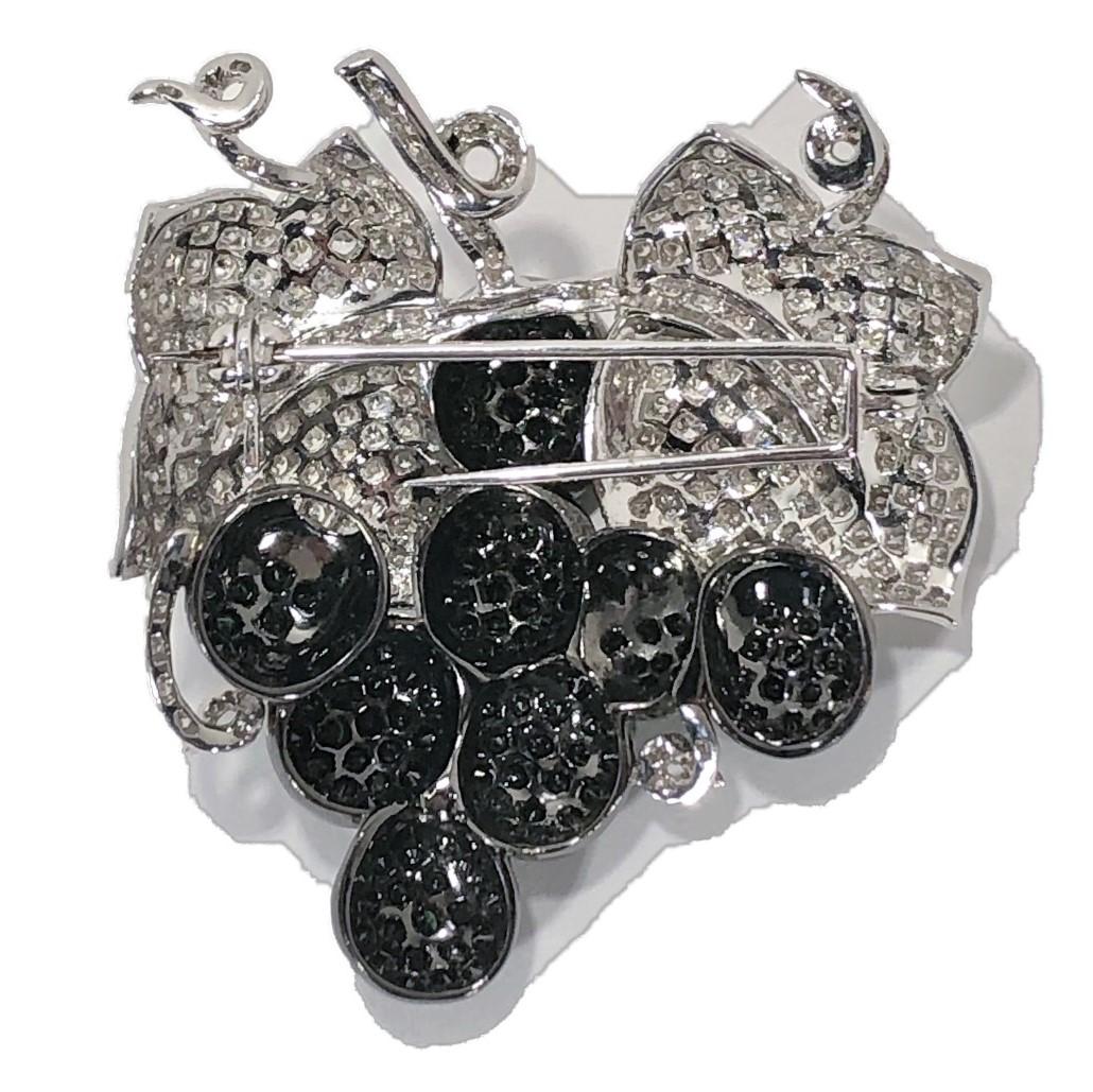 This very well articulated grape vine brooch is signed 18k and is lavishly set with several hundred white and black brilliant cut diamonds. Total diamond weight is approximately 6.00ct with that total being equally divided between white and black