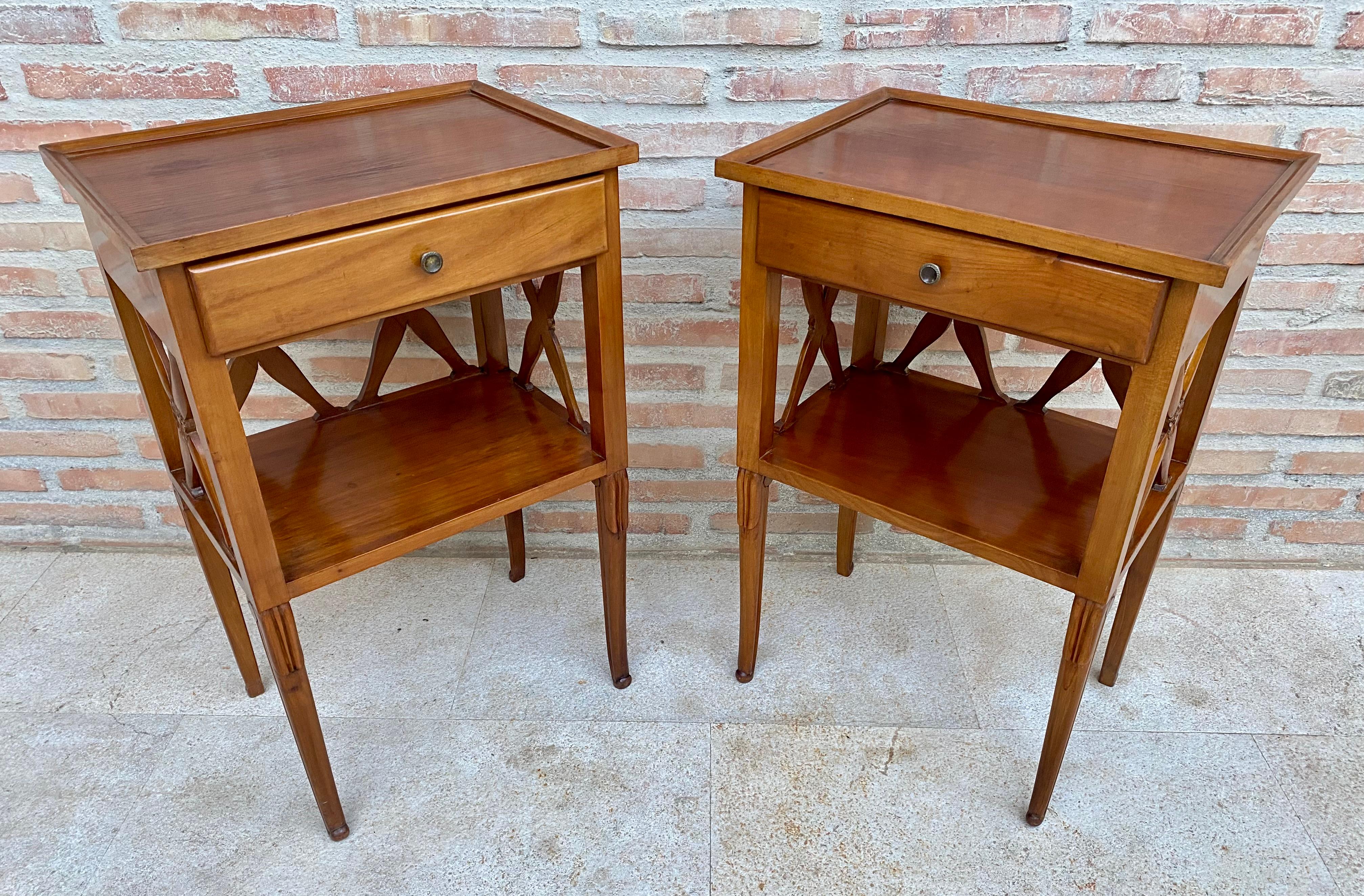 A pair of fruitwood lamp or bedside tables.

French, 1970s.

A superb design. The galleried tops above a recessed shelf and single drawer, raised on tapered legs. 
Design Period 1970 to 1979 
Production Period 1970 to 1979 
Style French,