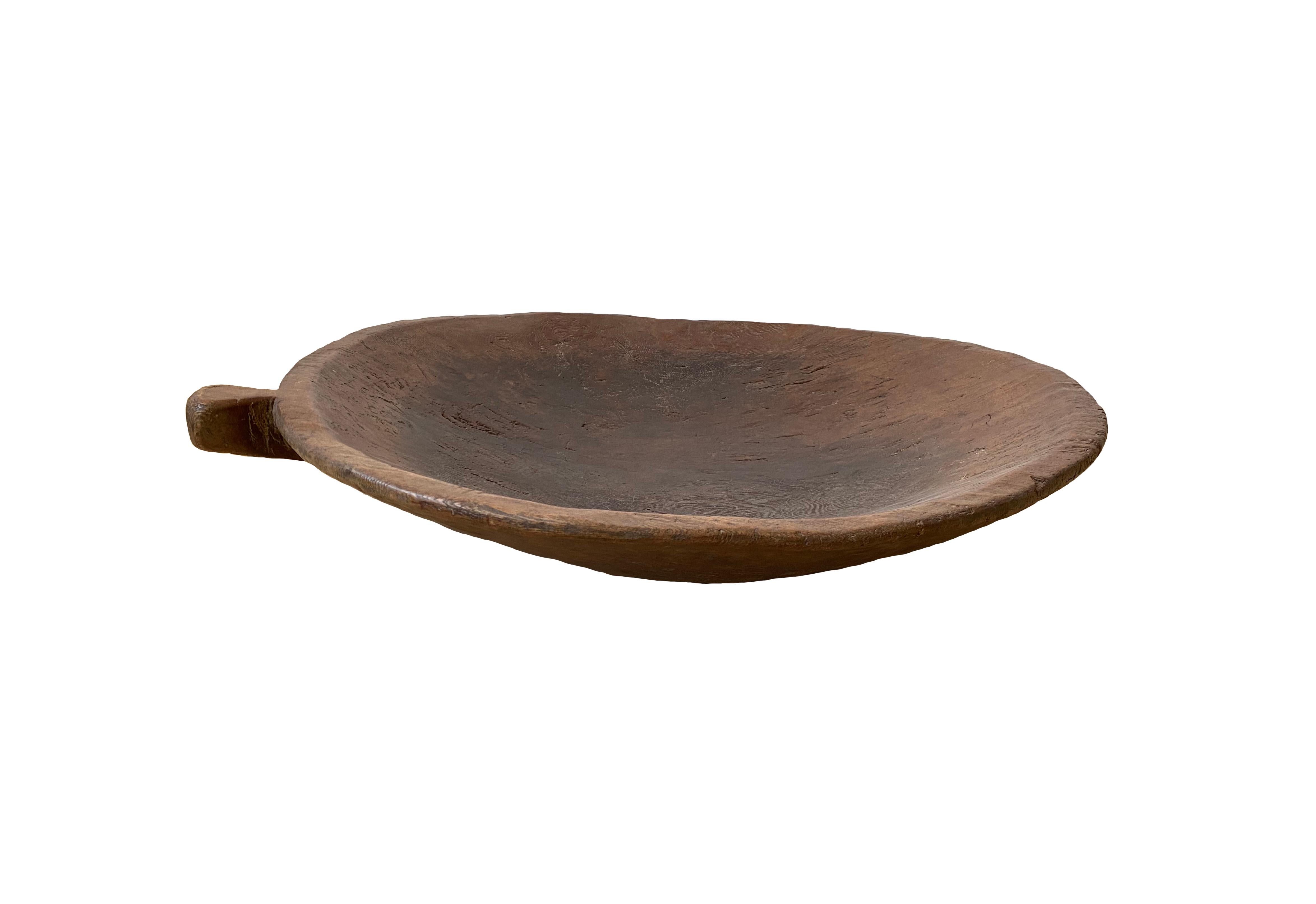 A fruitwood hand-crafted bowl from Timor Island, Indonesia from the early 20th century. The bowl was cut from a much larger slab of fruitwood. Despite its large size the bowl is relatively light and robust with a firm structure.

Dimensions: