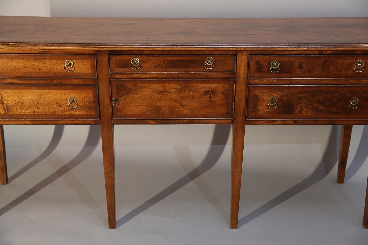 Fruitwood huntboard or sideboard has five drawers and one door, all banded in mahogany,
as well as the top.

Huntboard sits upon 6 square tapered legs, four in front and two in back.

This is a very handsome piece.
 